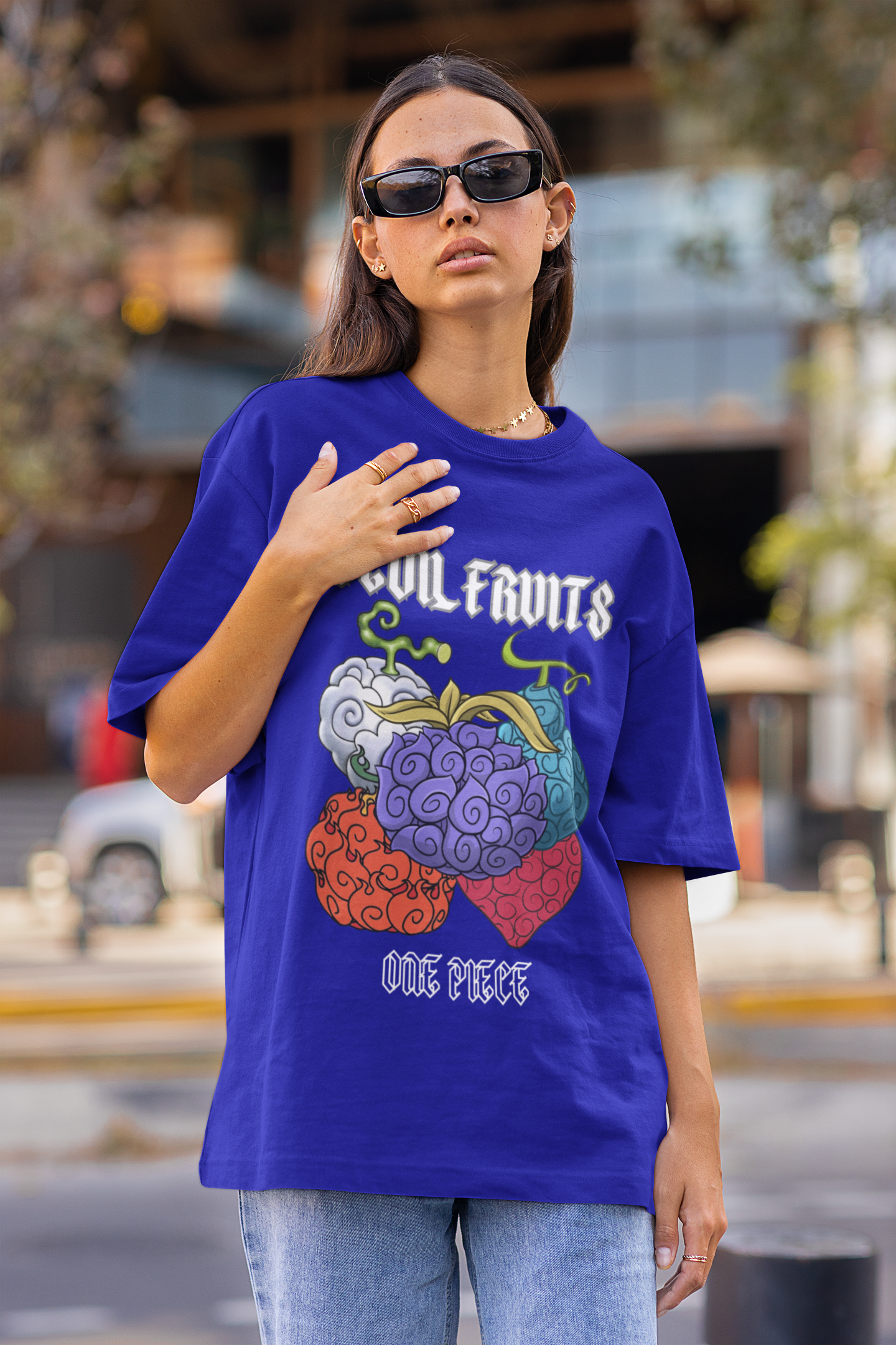 3rd front view of a female model wearing a royal blue oversized t-shirt featuring a design of a Devil Fruit from the One Piece anime.