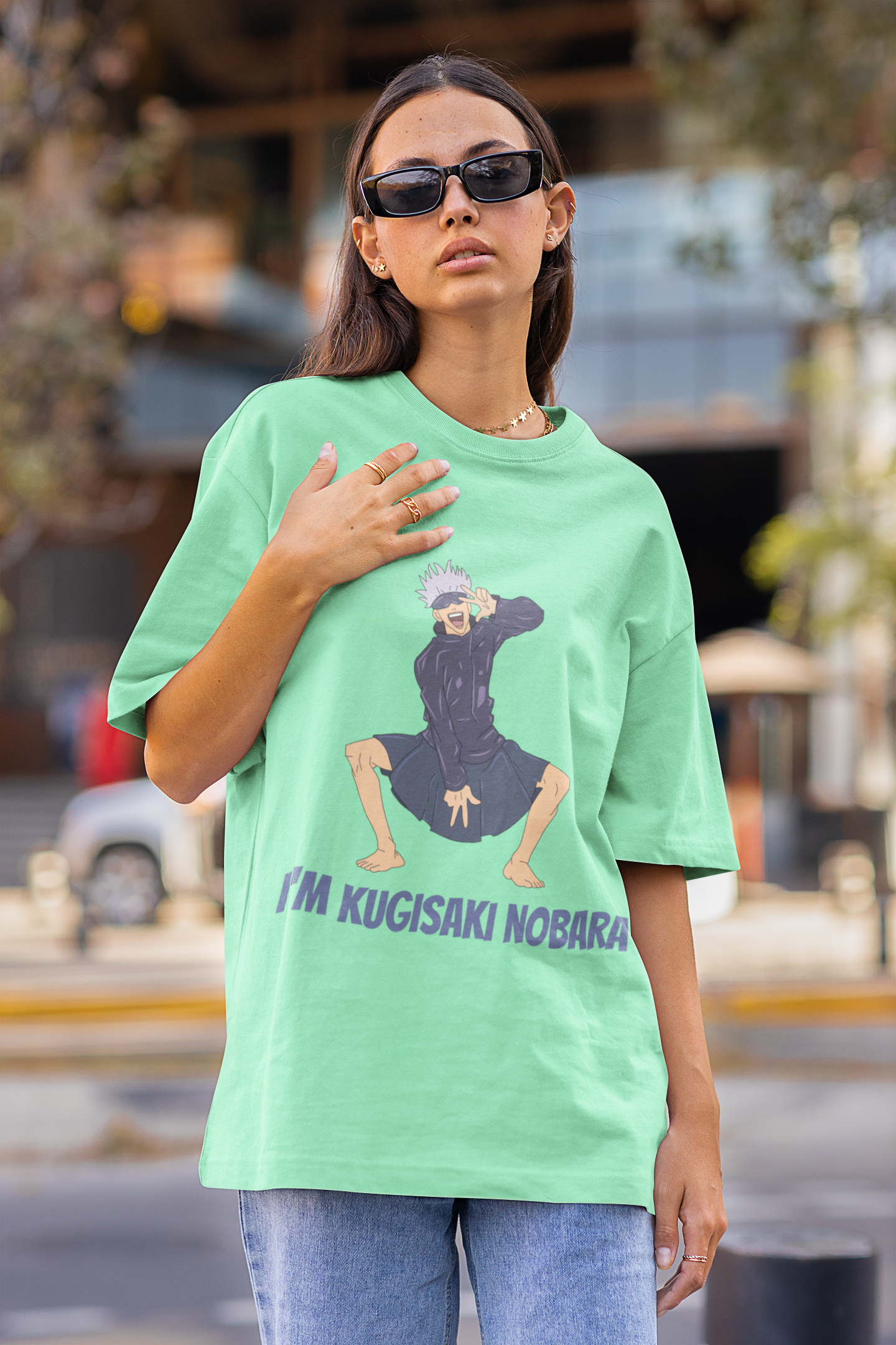First front view of a female model wearing an mint green oversized t-shirt featuring Satoru Gojo dressed as Nobara Kugisaki.