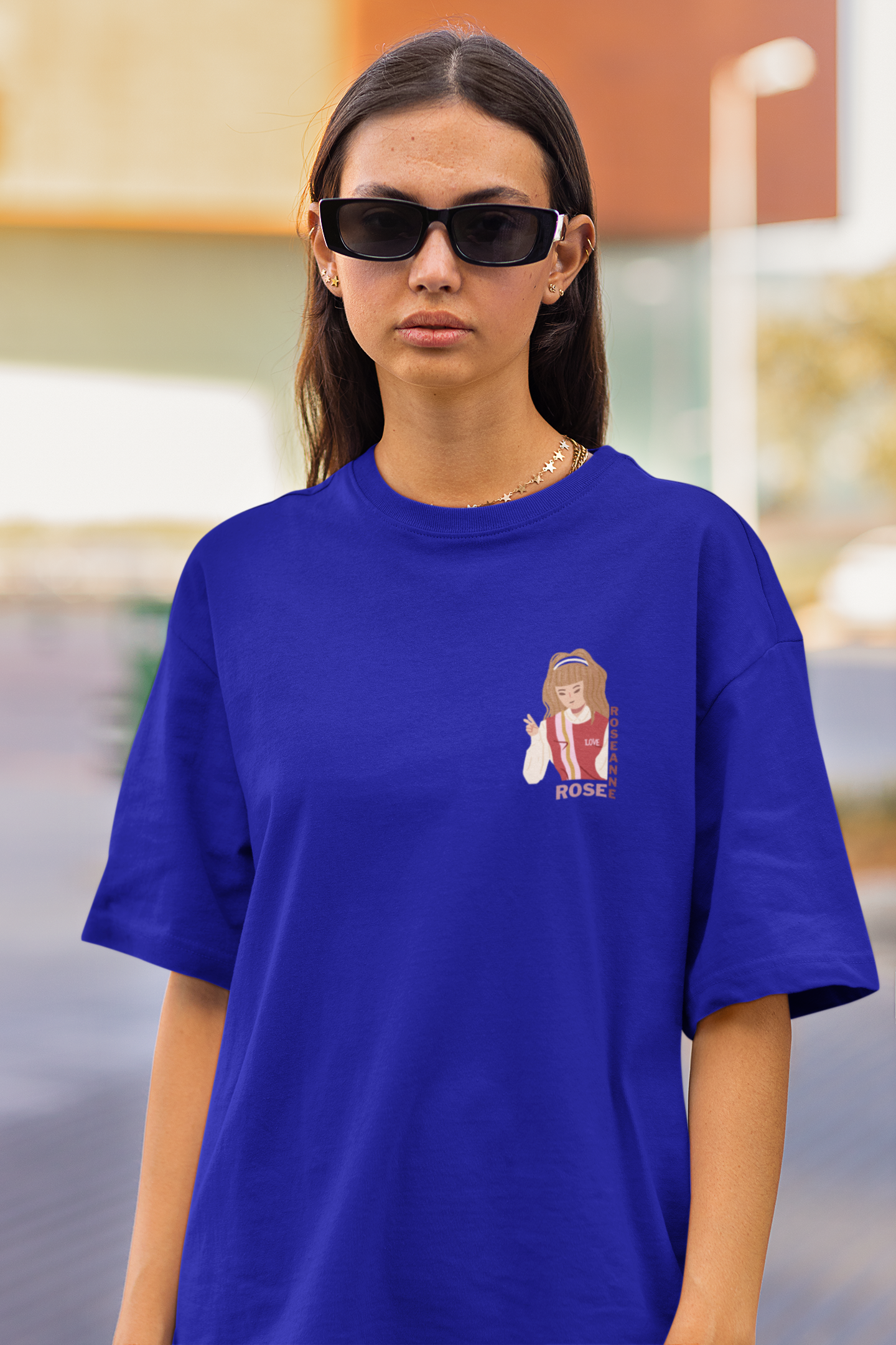 Front view of a female model wearing a royal blue oversized t-shirt featuring a stylish design inspired by Blackpink member Rosé. Ideal for fans of Rosé, Blackpink, and K-Pop music enthusiasts.