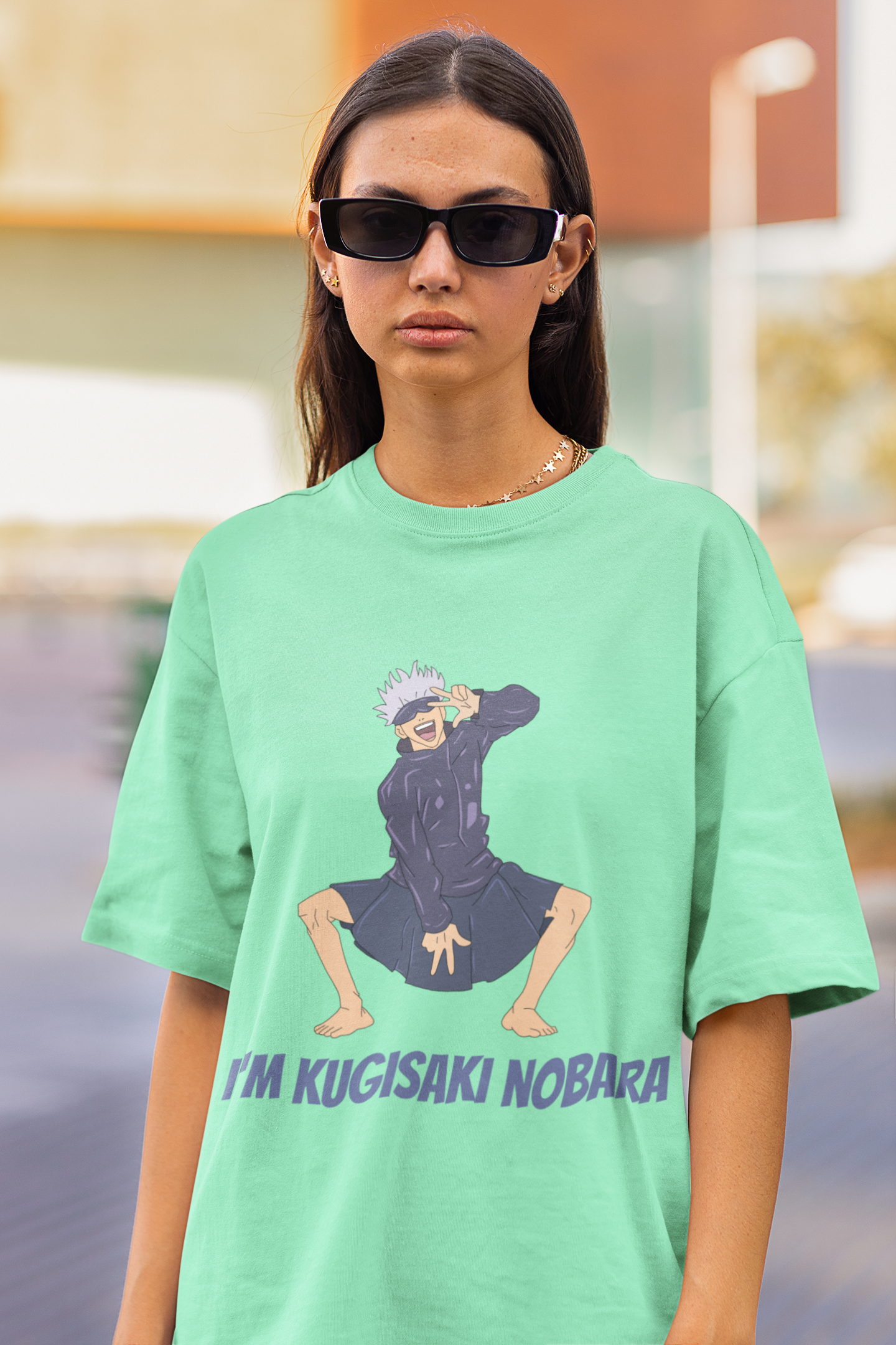2nd front view of a female model wearing an mint green oversized t-shirt featuring Satoru Gojo dressed as Nobara Kugisaki.