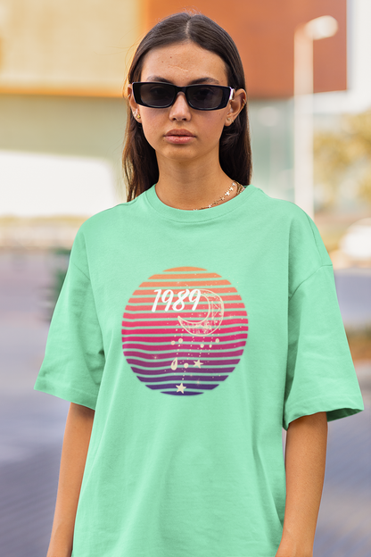 Closeup view of woman wearing mint green coloured Oversize T-shirt featuring Taylor Swift 1989 design, Taylor's Version, and Eras Tour Merch
