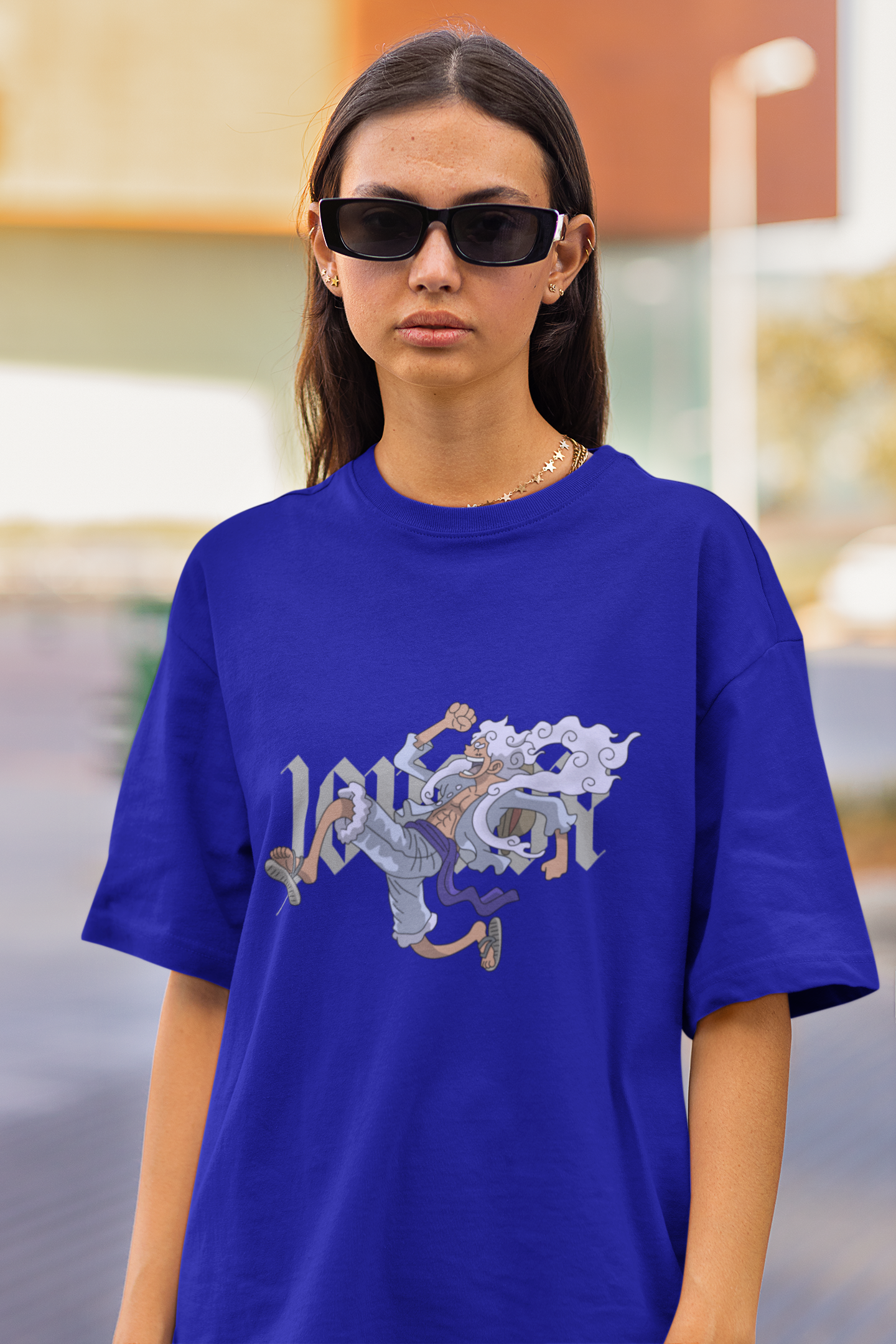 First front view of a female model wearing a royal blue oversized t-shirt featuring Luffy in his Gear 5 form from the One Piece anime.