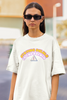 Close up front view of female model wearing an off-white oversized t-shirt with the hilarious message 