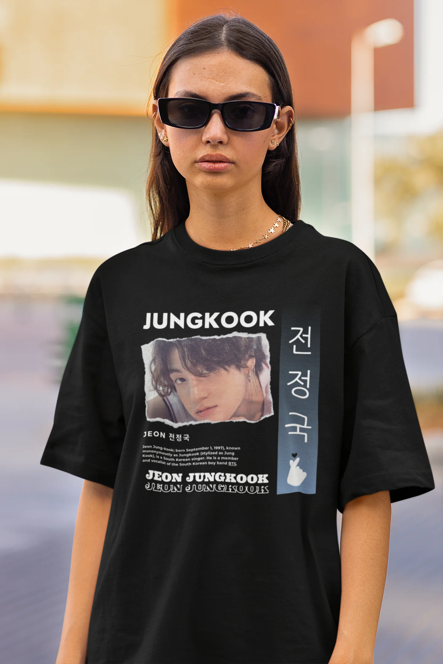 Closeup view of a female model wearing a black oversized t-shirt featuring a vibrant design inspired by BTS member Jungkook. Ideal for fans of BTS and K-Pop music in general.