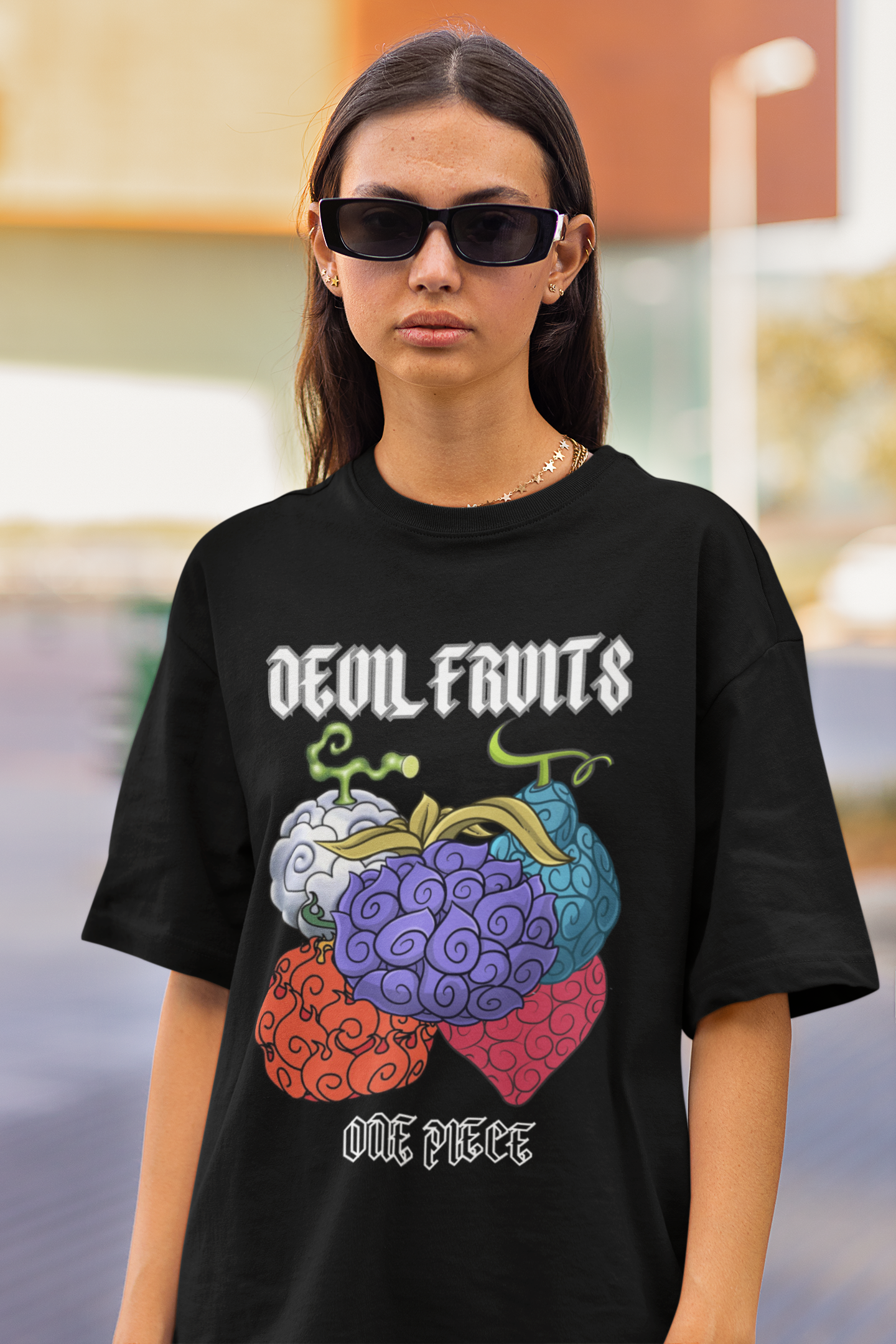 First front view of a female model wearing a black oversized t-shirt featuring a design of a Devil Fruit from the One Piece anime.