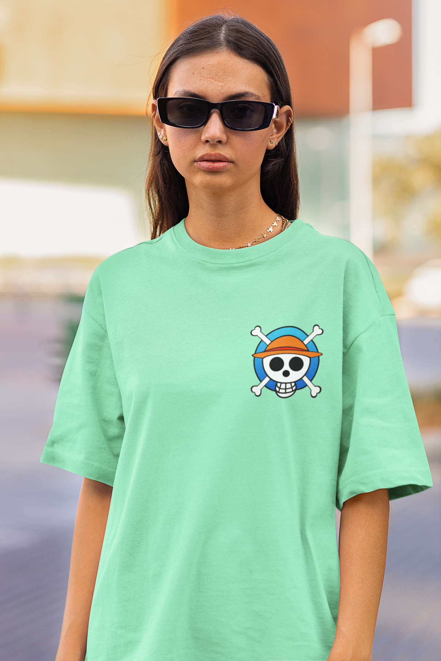 3rd front view of a female model wearing a mint green oversized t-shirt featuring chibi versions of the main characters from the One Piece anime.