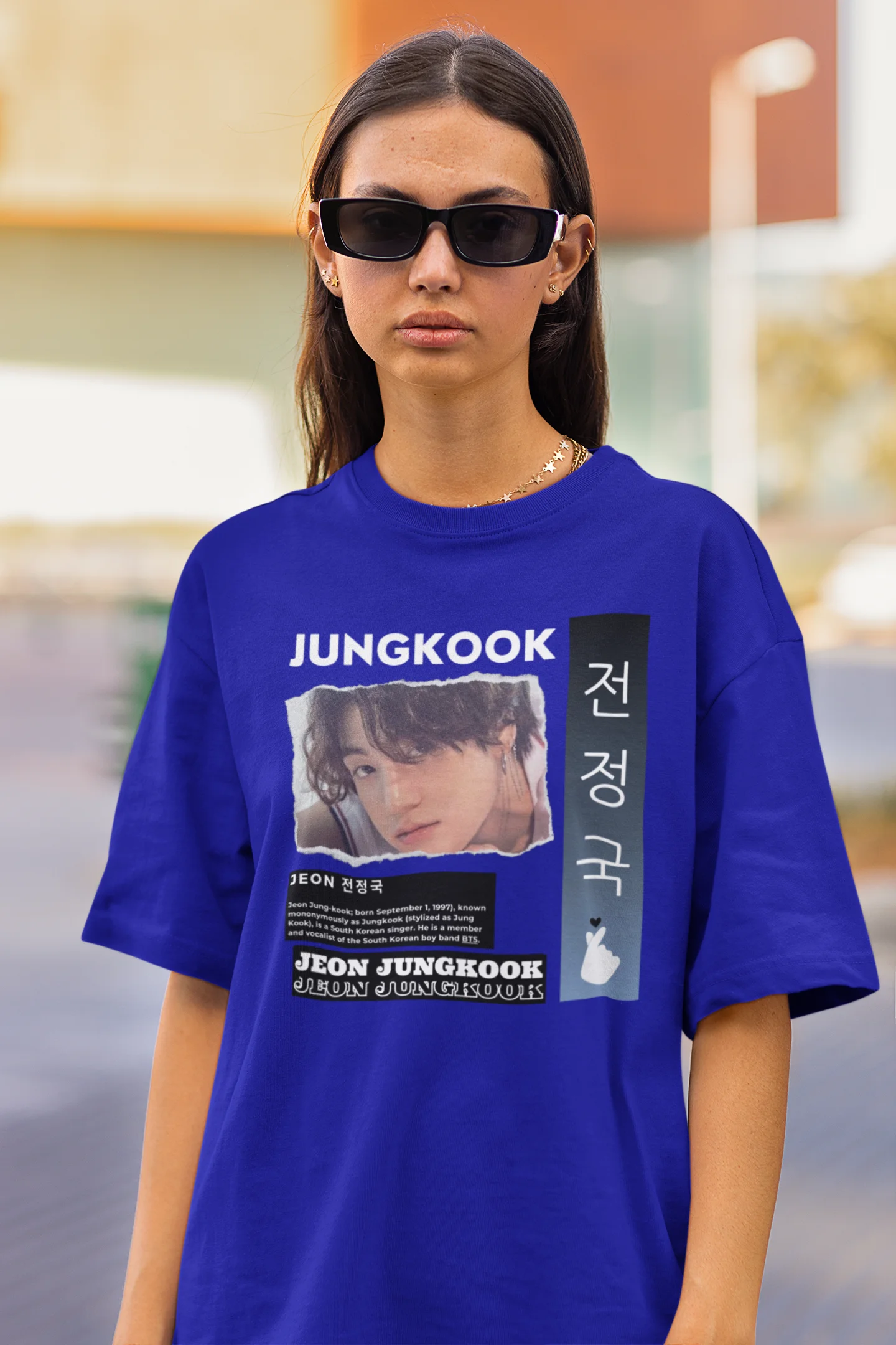 Close up view of a female model wearing a royal blue oversized t-shirt featuring a vibrant design inspired by BTS member Jungkook. Ideal for fans of BTS and K-Pop music in general.