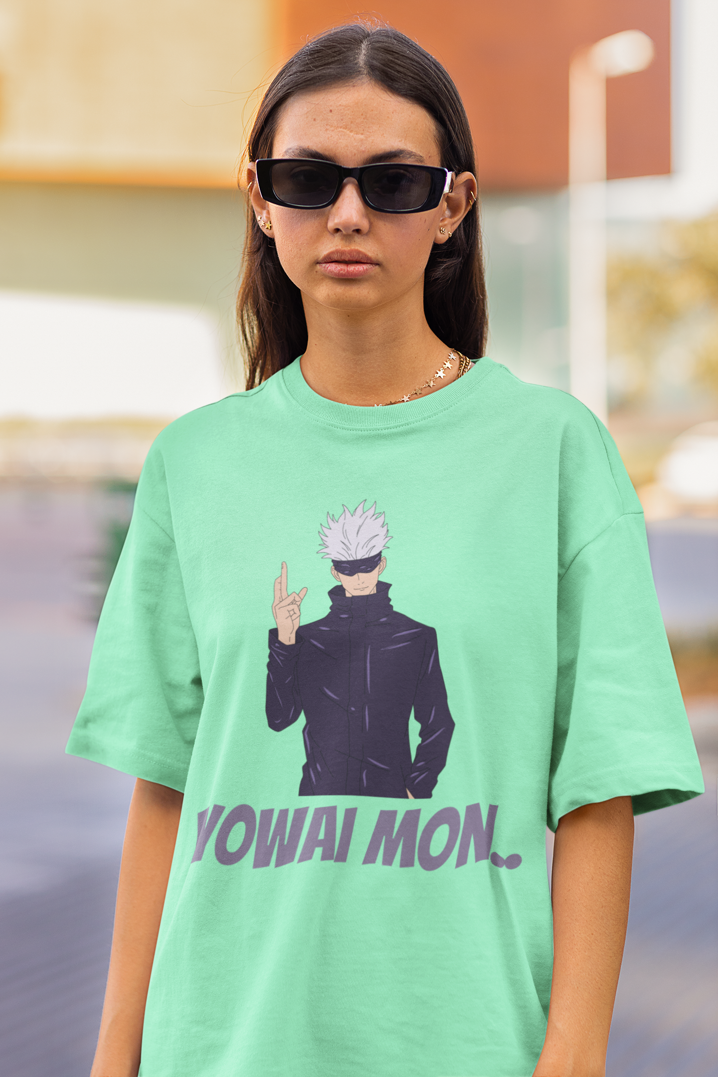 First front view of a female model wearing a mint green oversized t-shirt featuring Gojo Satoru with his fingers crossed and the text "Yowai Mon."