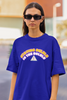 Close up view of female model wearing an royal blue oversized t-shirt with the hilarious message 