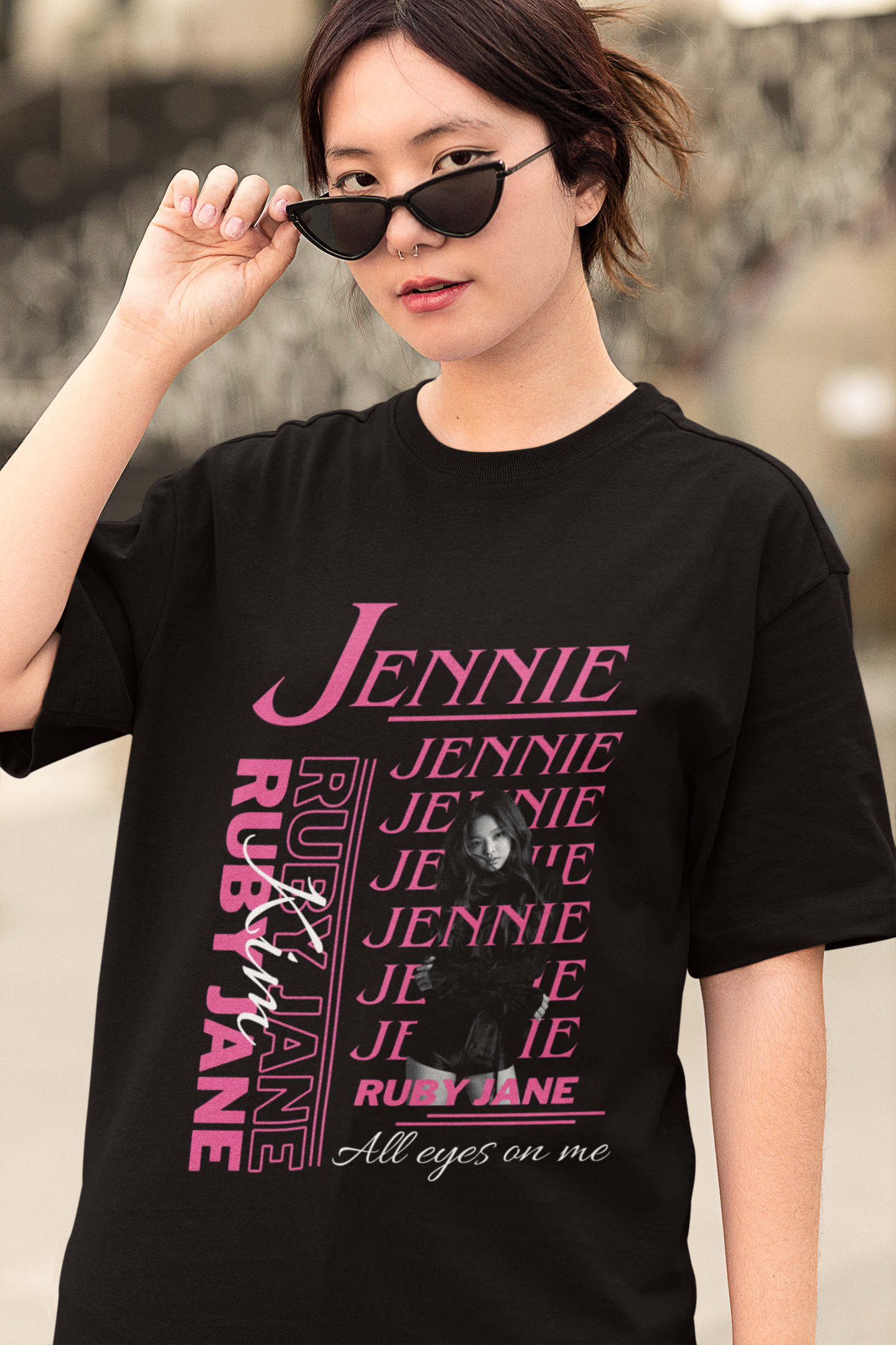 Front view of female model wearing a black oversized t-shirt featuring a stylish design inspired by Blackpink member Jennie. Ideal for fans of Jennie, Blackpink, and K-Pop music enthusiasts interested in idol fashion.