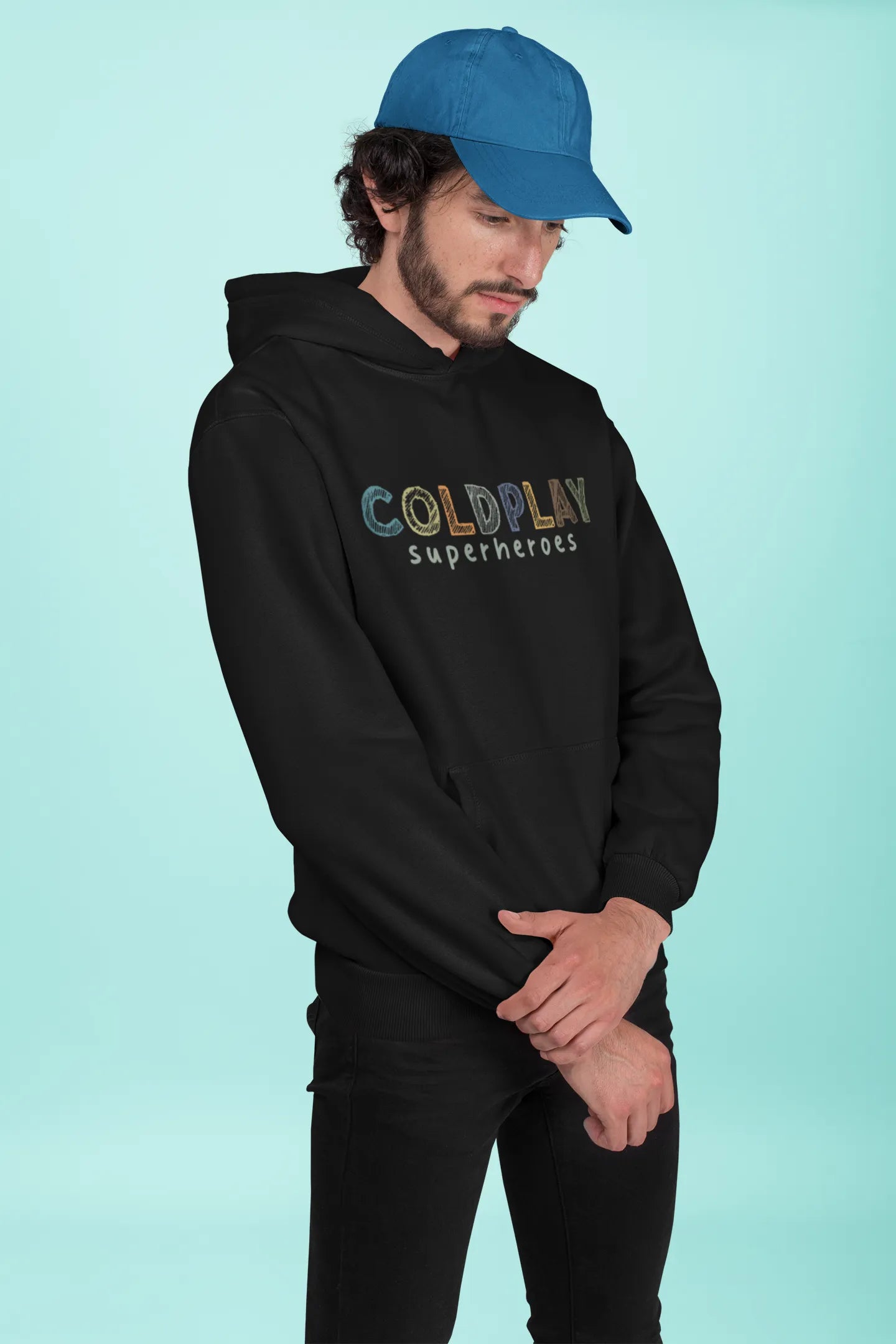 1st front view of a male model wearing an black hoodie with a design inspired by the "Something Just Like This" music video, featuring the word "Superheroes".