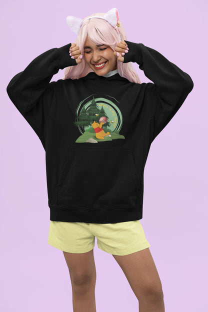 Front view of a female model wearing a black hoodie with a Winnie the Pooh design, showing the Disney bear eating honey from a jar in a forest.