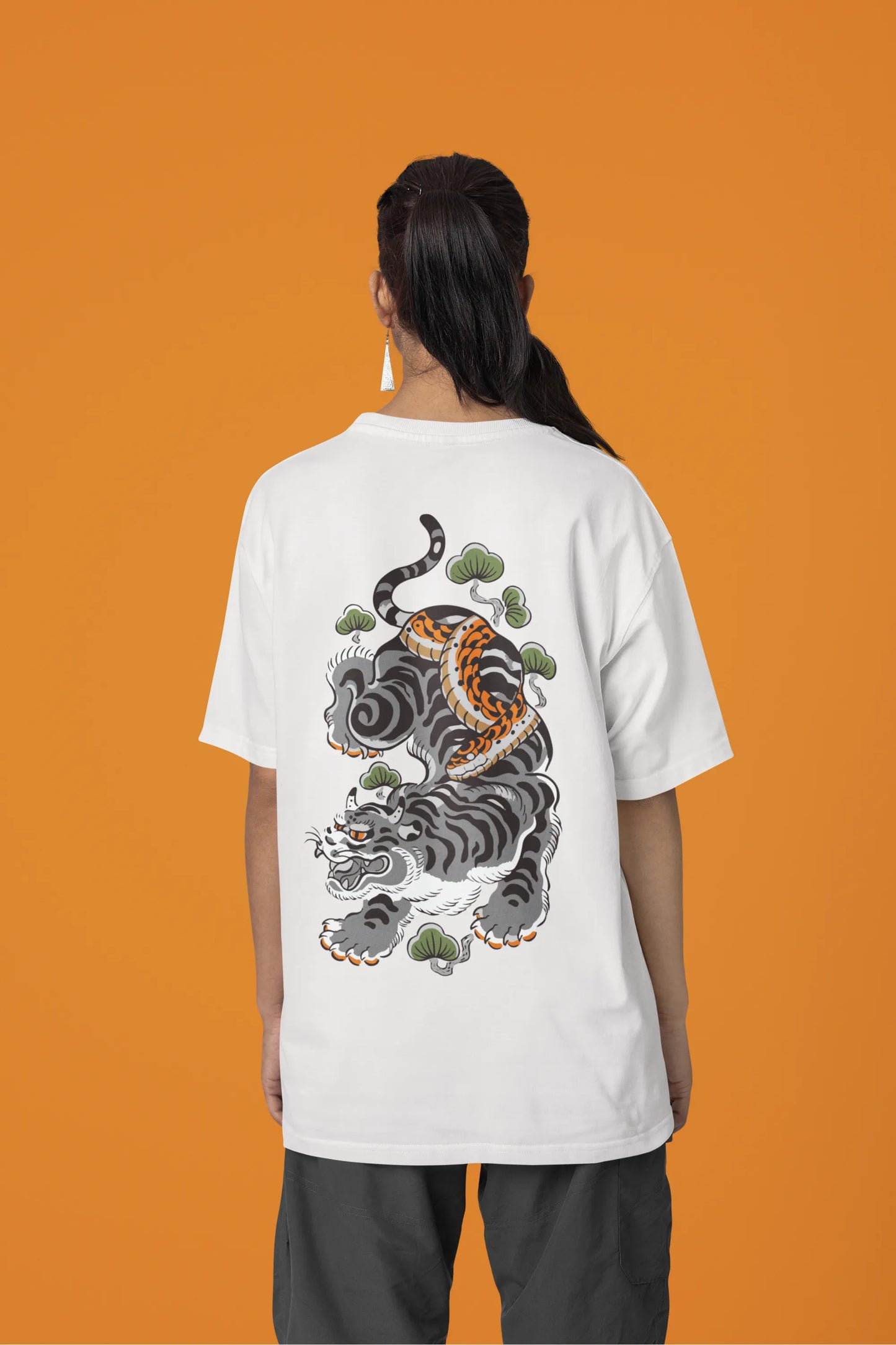 Back view of a female model wearing a off-white oversized tee with a Japanese art style tiger design.