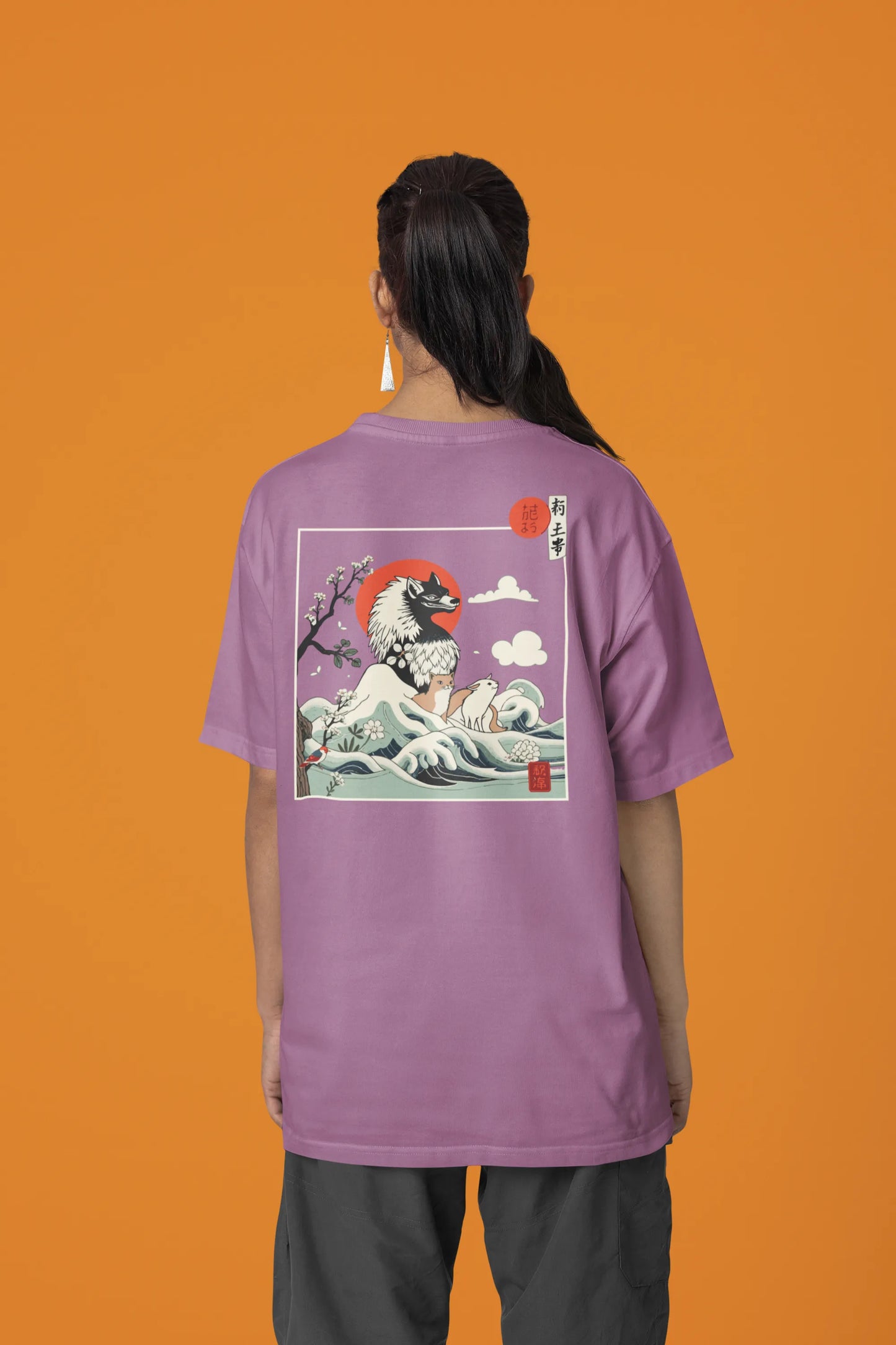 Back view of a female model wearing a dirty purple oversized tee with a design of a wolf surveying a Japanese landscape.