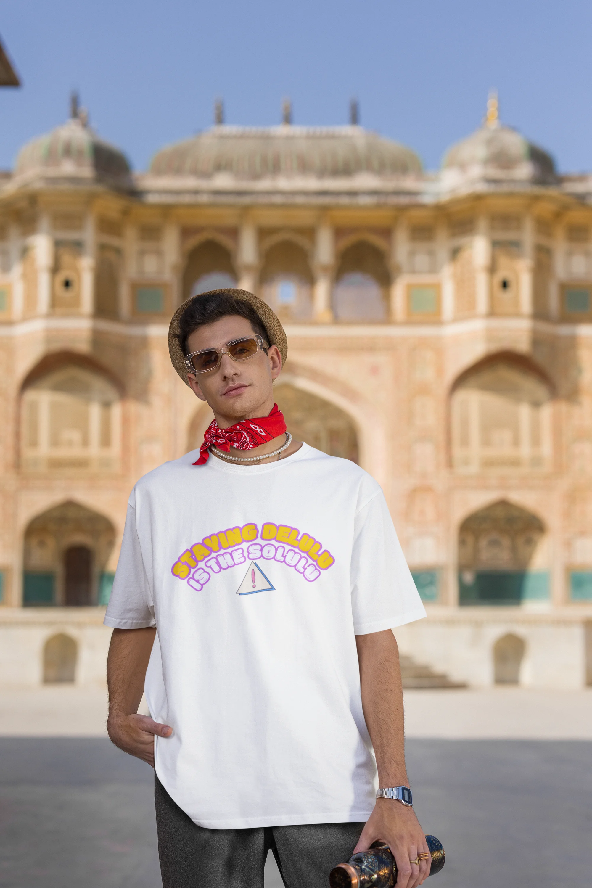 Third front view male model wearing an off-white oversized t-shirt with the hilarious message "Stay Delulu" in a bold design. Ideal for those who love trendy slang and lighthearted humor.