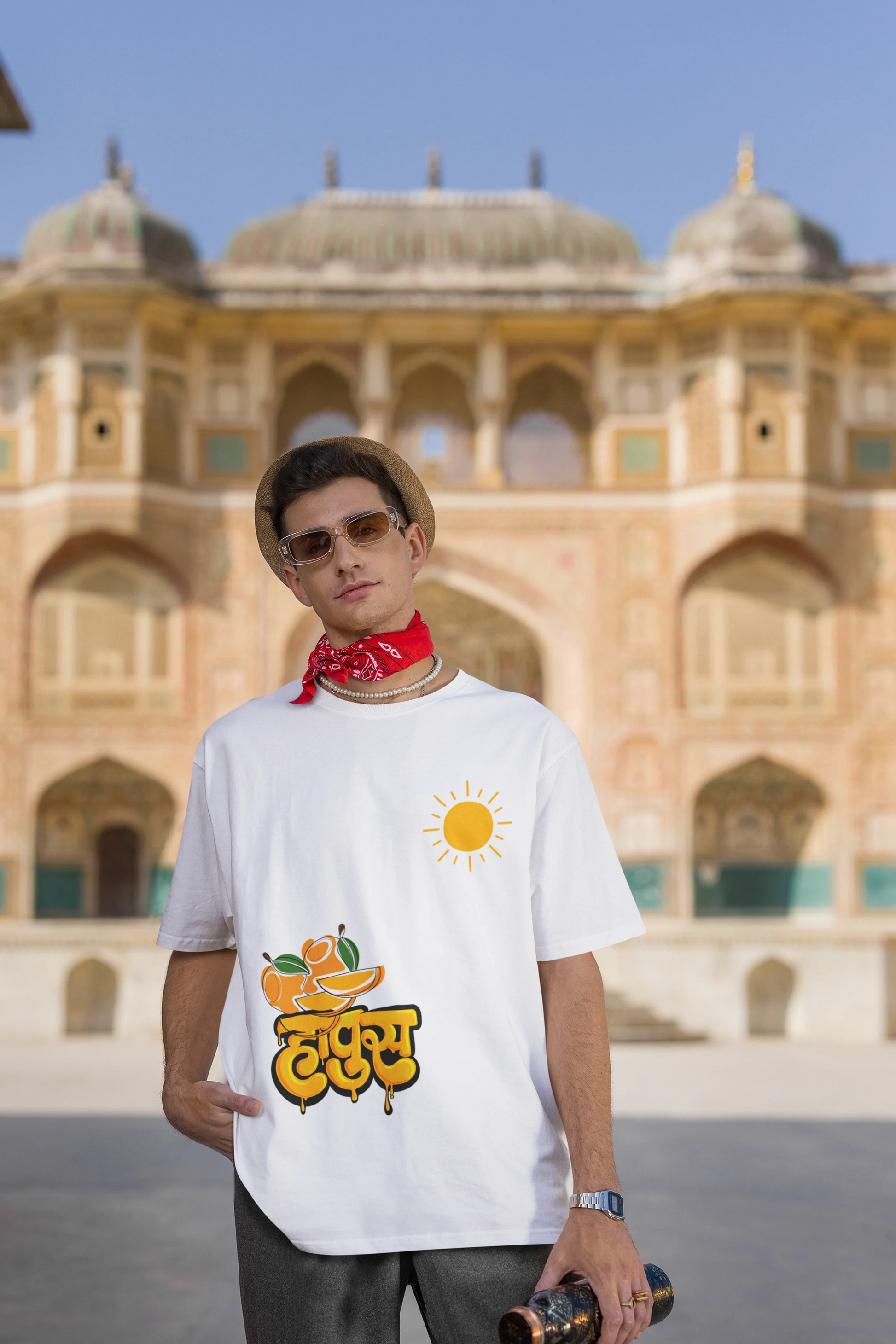 Third front view of male model wearing an off-white oversized t-shirt featuring a design inspired by the Marathi word "Hapus," meaning Alphonso mango. Ideal for fans of Marathi culture, foodies, and anyone who loves the king of fruits.
