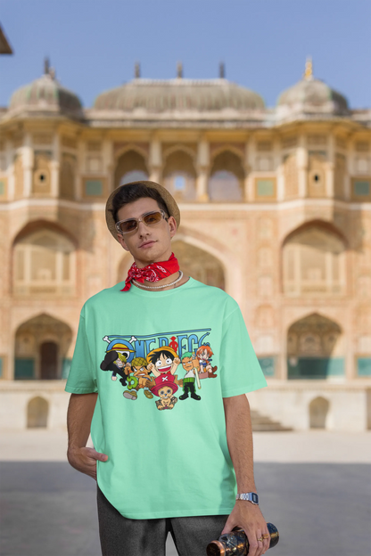 3rd front view of a male model wearing a mint green oversized t-shirt featuring chibi versions of the Straw Hat Crew from the One Piece anime.