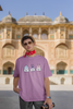 Third image of male model wearing Disney-themed dirty purple oversized tee with a cute cartoon design