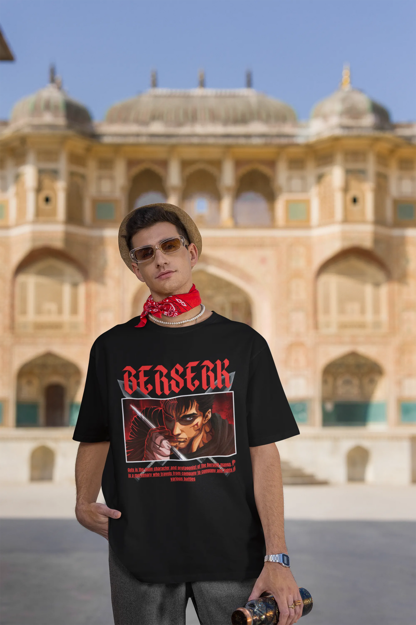 3rd front view of a male model wearing an black oversized t-shirt featuring Guts from the Berserk anime with the text "Berserk" across the design.