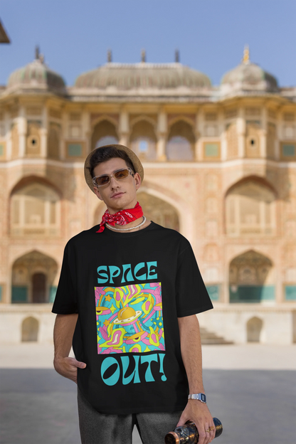Third image of male model wearing an black oversized "Spaced Out" t-shirt featuring a vibrant color mashup design that evokes a sense of space exploration, playful aliens, and distant galaxies.