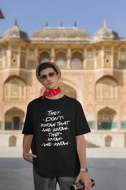 Third image of male model wearing black oversized t-shirt with F.R.I.E.N.D.S series inspired designs, embodying Phoebe's unique humor with the quote 'They Know We Know'