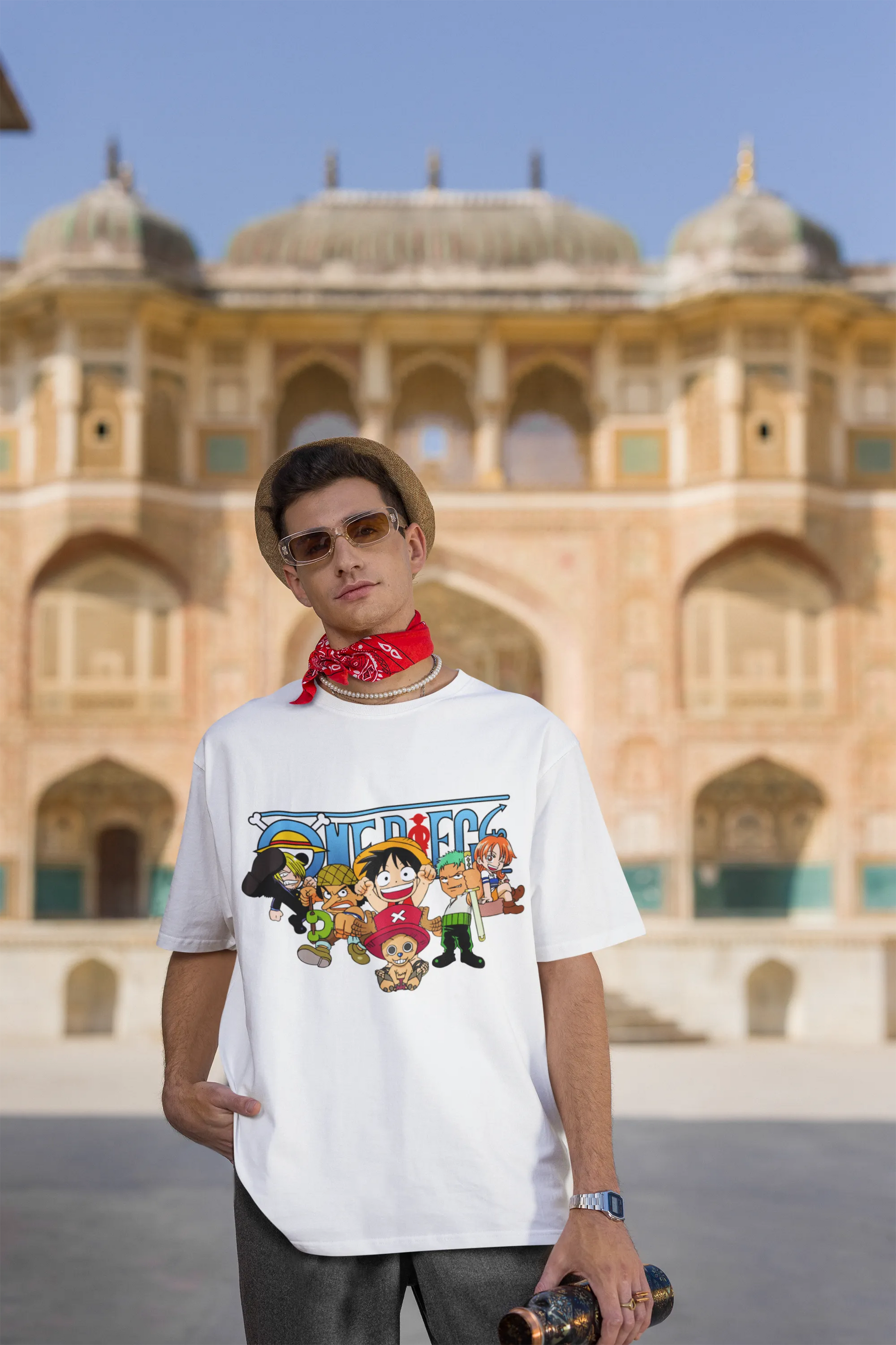 3rd front view of a male model wearing an off-white oversized t-shirt featuring chibi versions of the Straw Hat Crew from the One Piece anime.