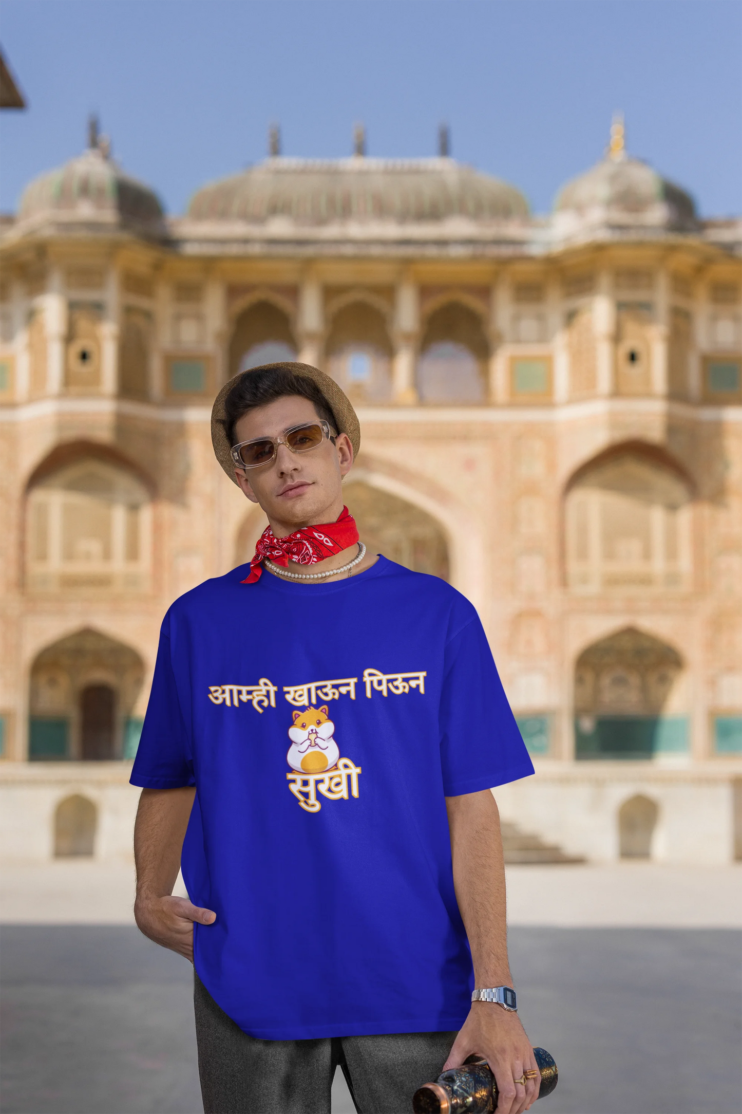 Third front view of male model wearing a royal blue oversized t-shirt featuring a design inspired by the Marathi dish "Sukhi," a dry lentil curry. Perfect for fans of Marathi culture, foodies, and anyone who loves a taste of home.