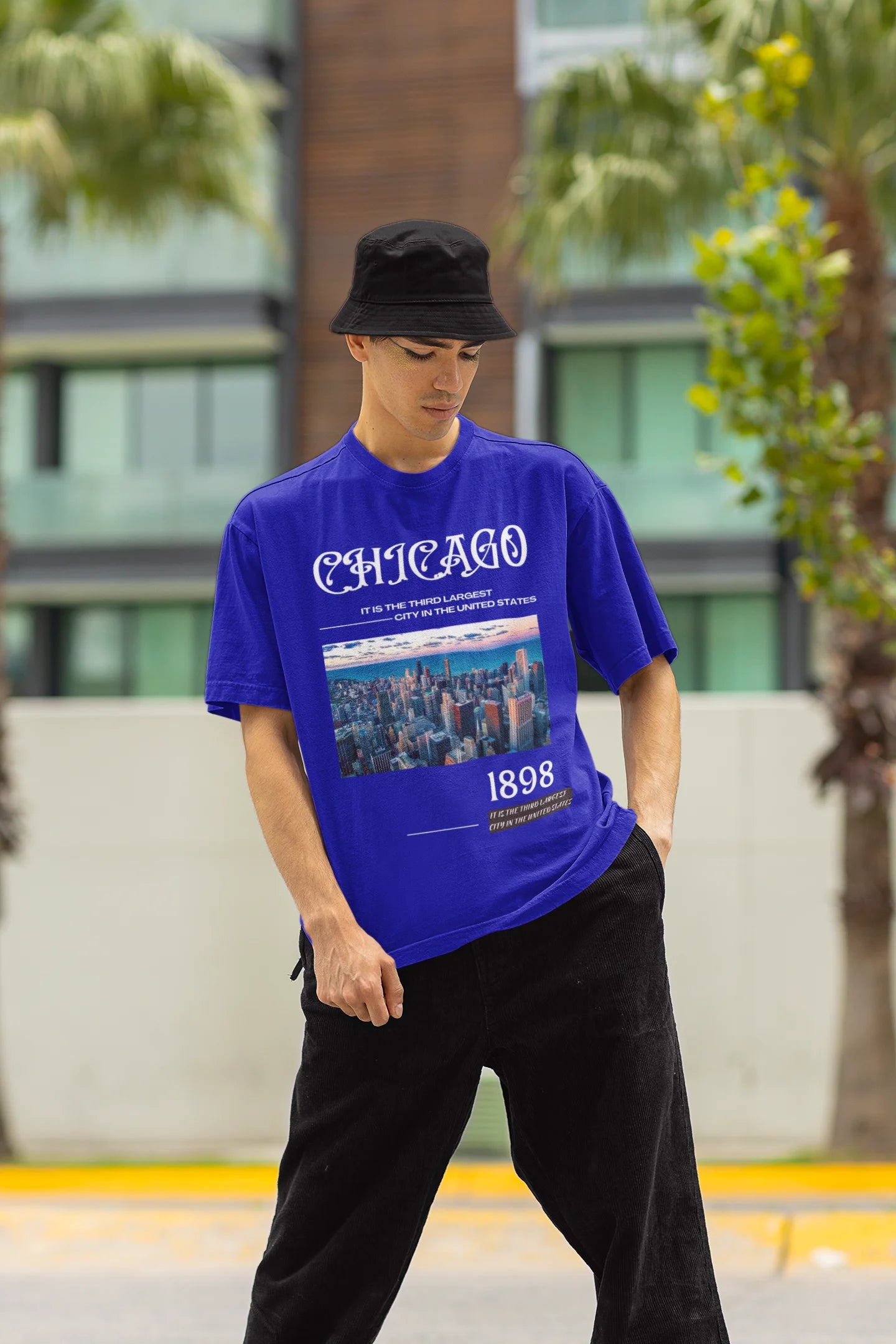 Front view of male model wearing a royal blue oversized t-shirt with a Chicago skyline design, offering a relaxed urban aesthetic.