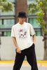 Front view of male model wearing an off-white oversized t-shirt with a psychedelic skull flower design, perfect for a hippie, trance, or groovy style.