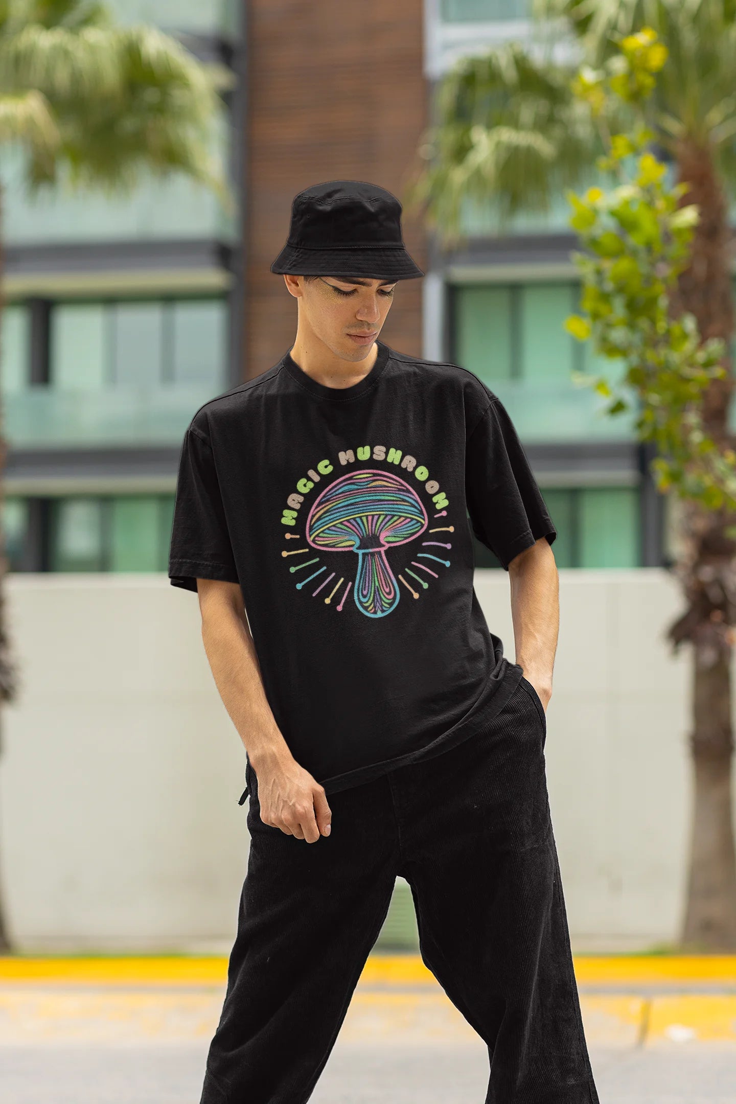 Front view of a male model wearing a black oversized t-shirt featuring a psychedelic magic mushroom with an aura, perfect for a hippie, trance, or groovy style.