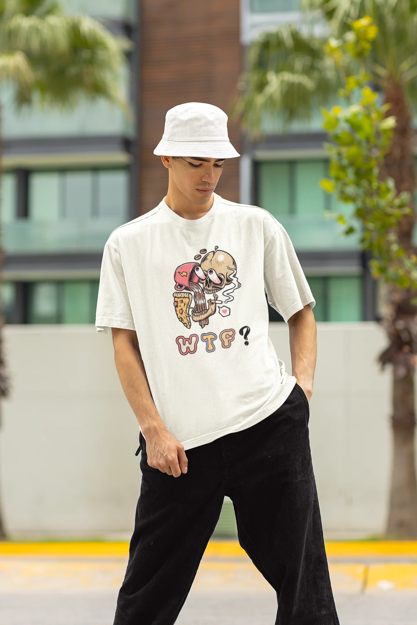 Front view of a male model wearing an off white oversized t-shirt featuring a skull enjoying coffee, pizza, and smoking, offering a unique and edgy aesthetic.