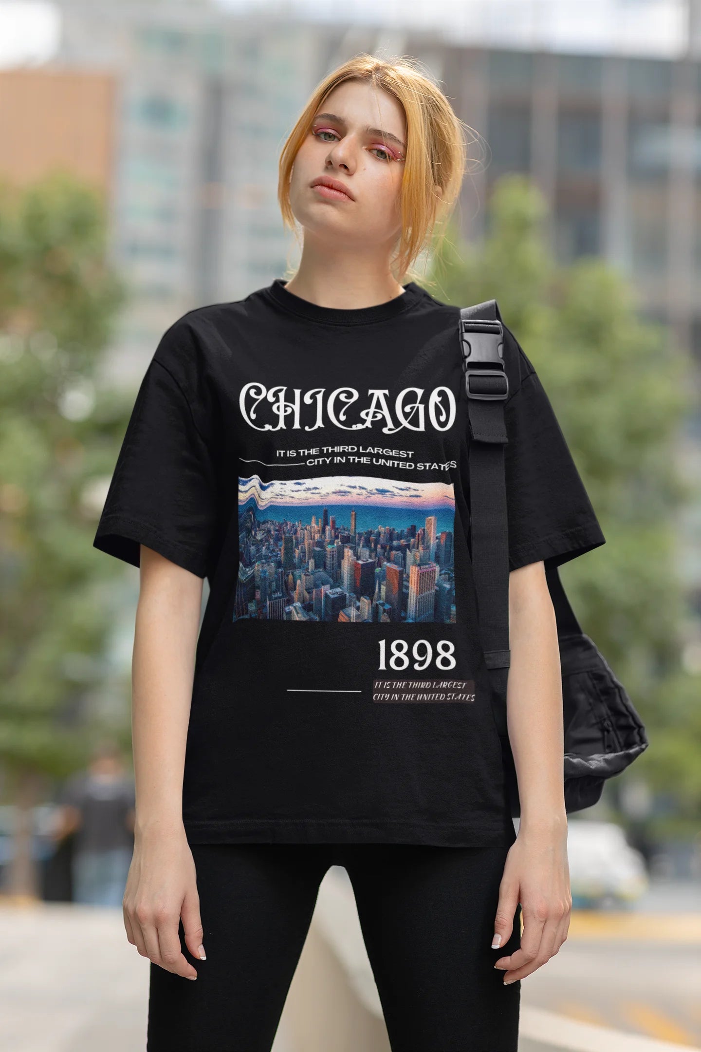 First front view of female model wearing a black oversized t-shirt with a Chicago skyline design, offering a relaxed urban aesthetic.
