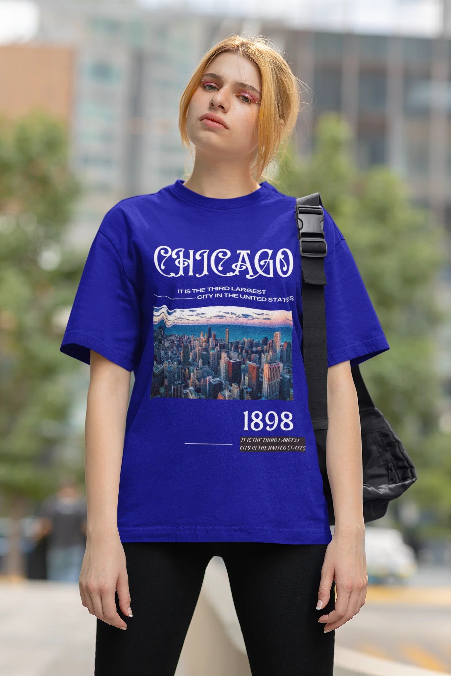 First front view of a female model wearing a royal blue oversized t-shirt with a Chicago skyline design, offering a relaxed urban aesthetic.
