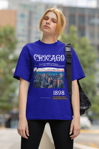 First front view of a female model wearing a royal blue oversized t-shirt with a Chicago skyline design, offering a relaxed urban aesthetic.