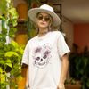 Front view of female model wearing an off-white oversized t-shirt with a psychedelic skull flower design, perfect for a hippie, trance, or groovy style.