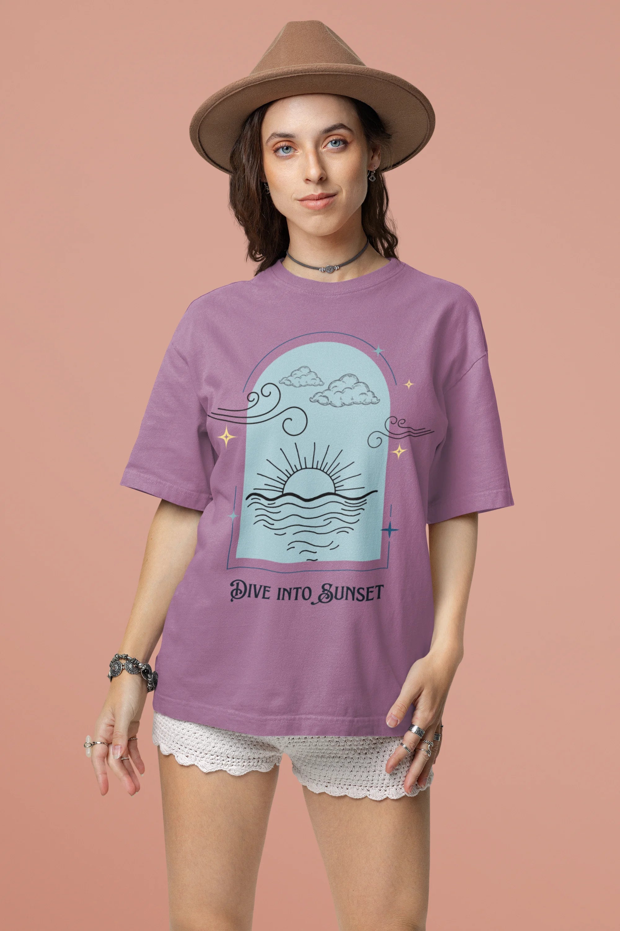 Second front view of a female model wearing a dirty purple oversized t-shirt with a beautiful outline of the sun setting into the sea, offering a serene and coastal aesthetic.