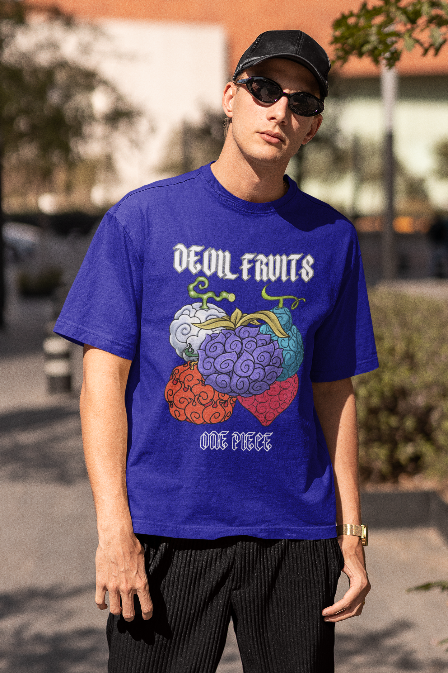 2nd front view of a male model wearing a royal blue oversized t-shirt featuring a design of a Devil Fruit from the One Piece anime.