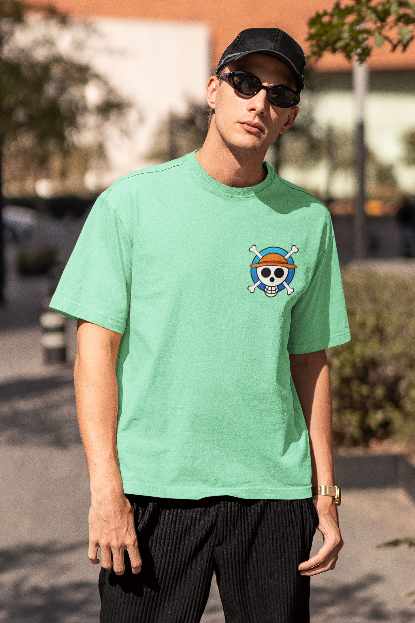 3rd front view of a male model wearing a mint green oversized t-shirt featuring chibi versions of the main characters from the One Piece anime.