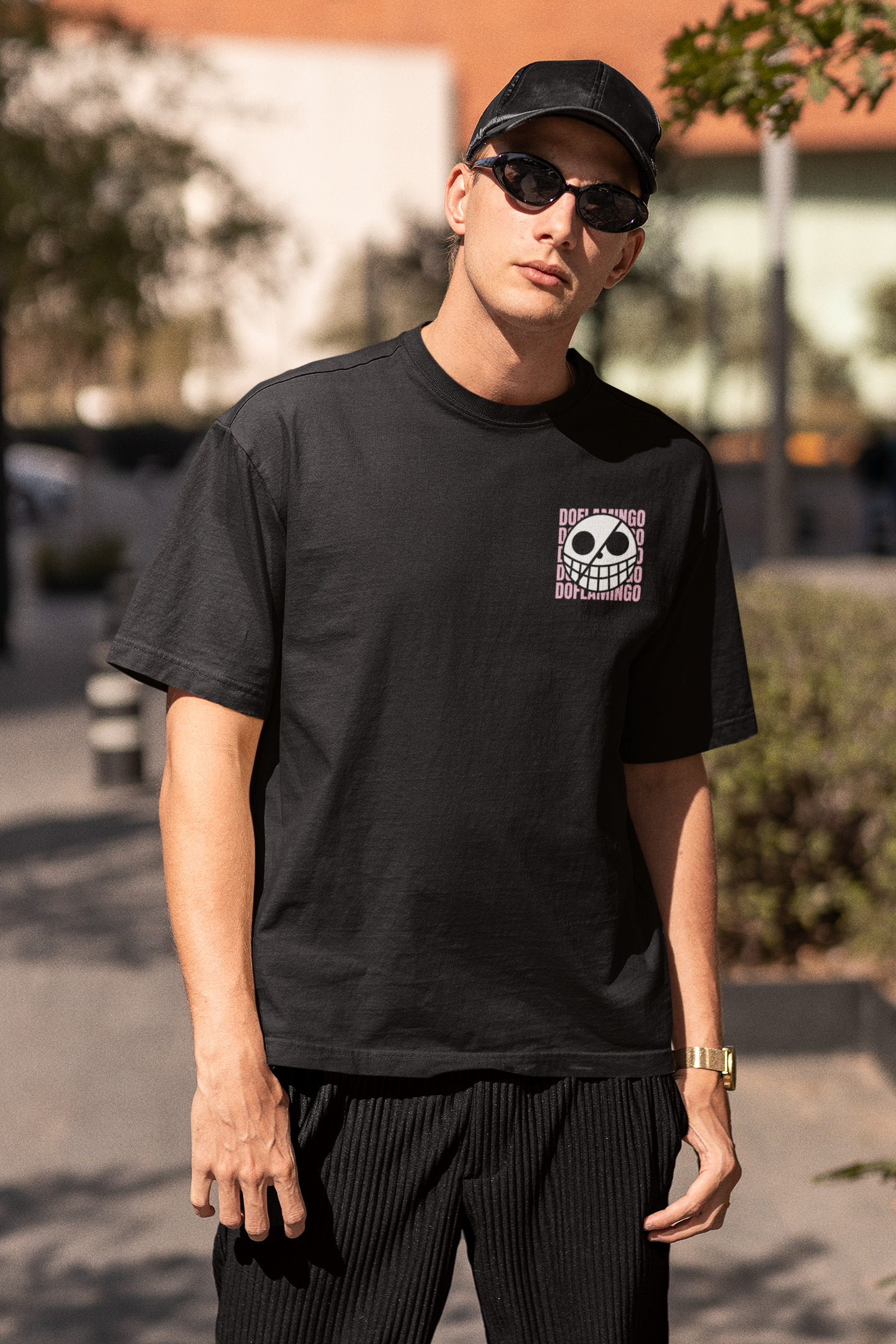 3rd front view of a male model wearing a black oversized t-shirt featuring Donquixote Doflamingo from the One Piece anime.
