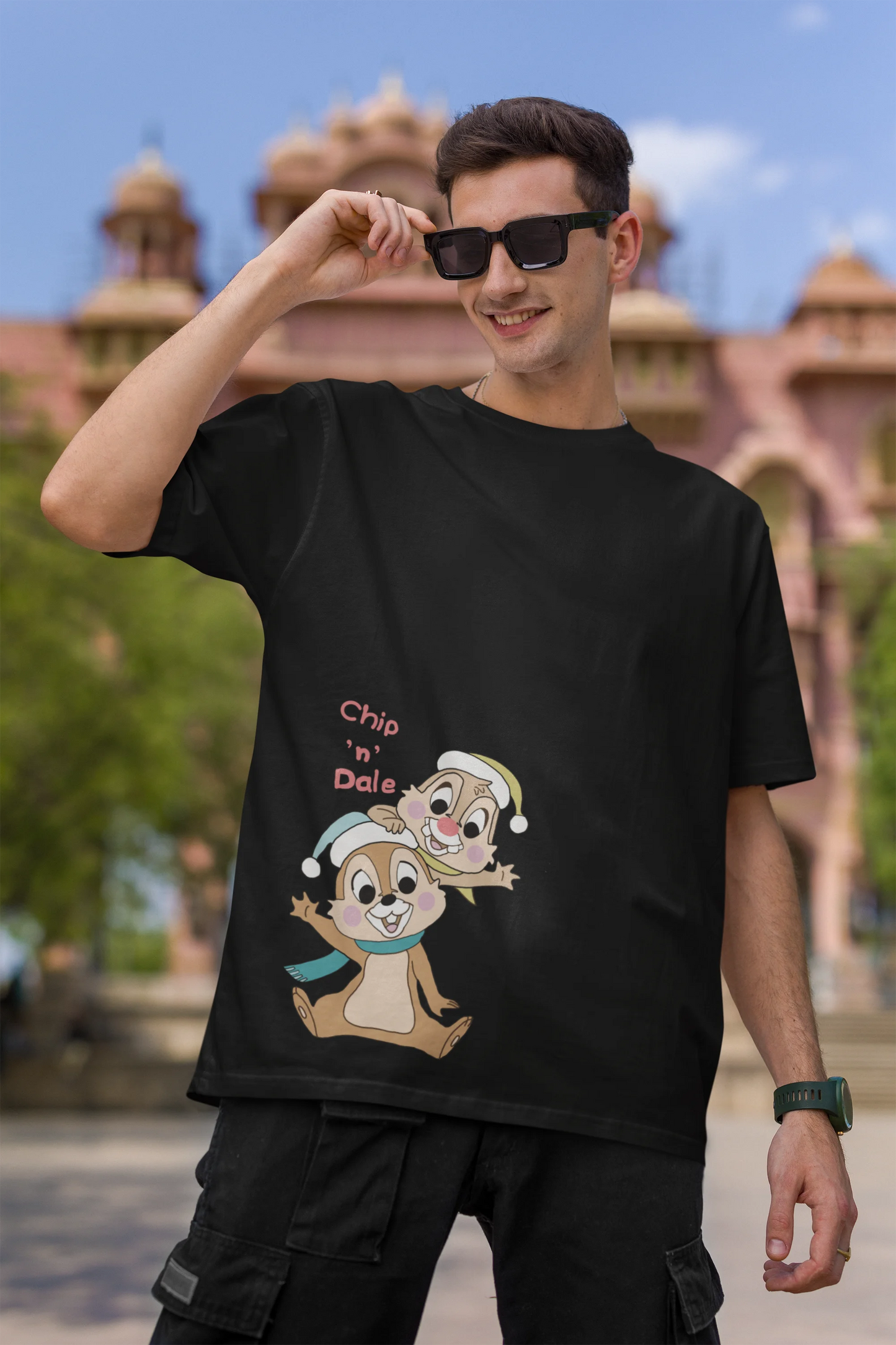 First image of male model wearing black oversized tee with a Disney's Chip and Dale design, featuring the adorable duo in a playful scene.
