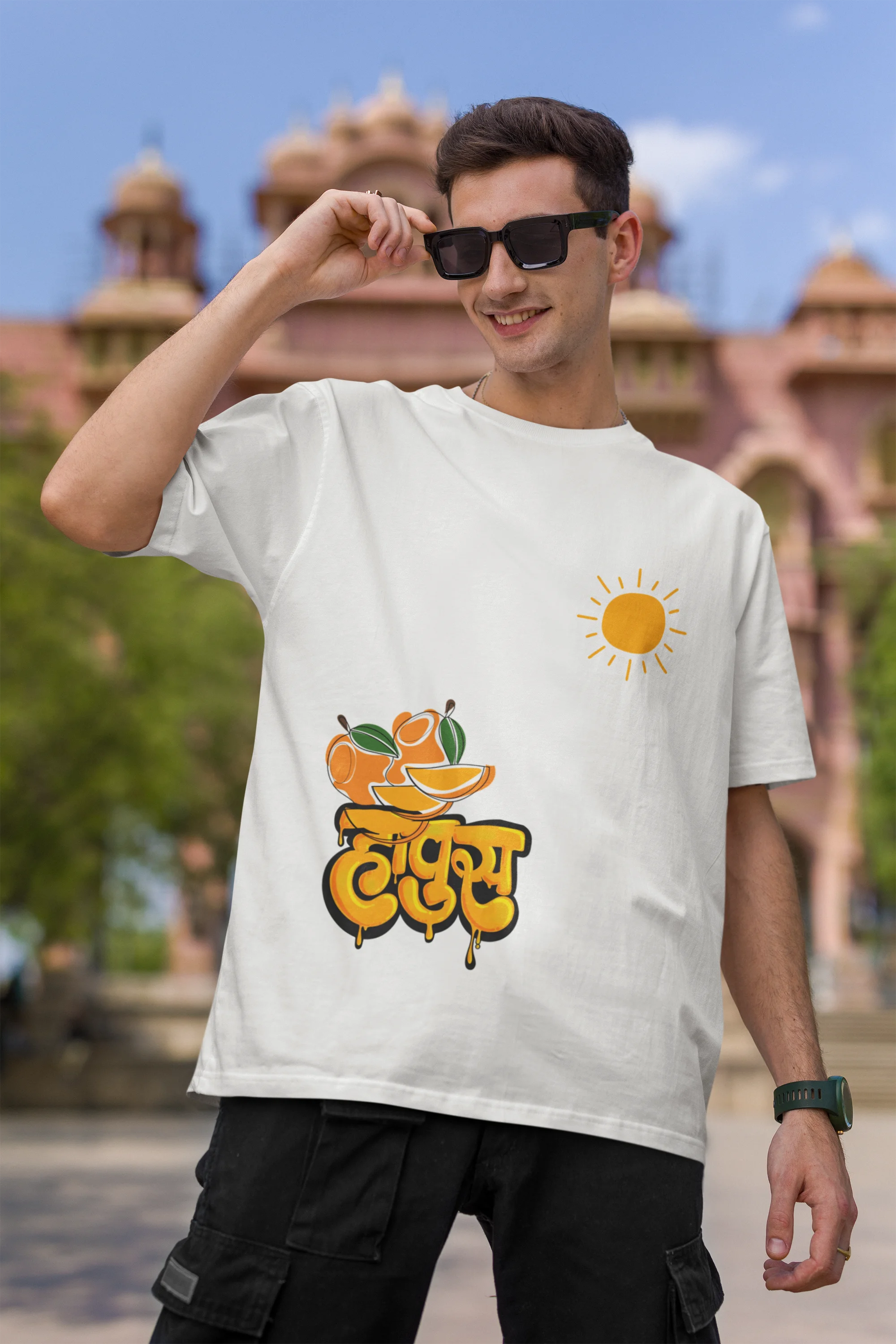 First front view of male model wearing an off-white oversized t-shirt featuring a design inspired by the Marathi word "Hapus," meaning Alphonso mango. Ideal for fans of Marathi culture, foodies, and anyone who loves the king of fruits.