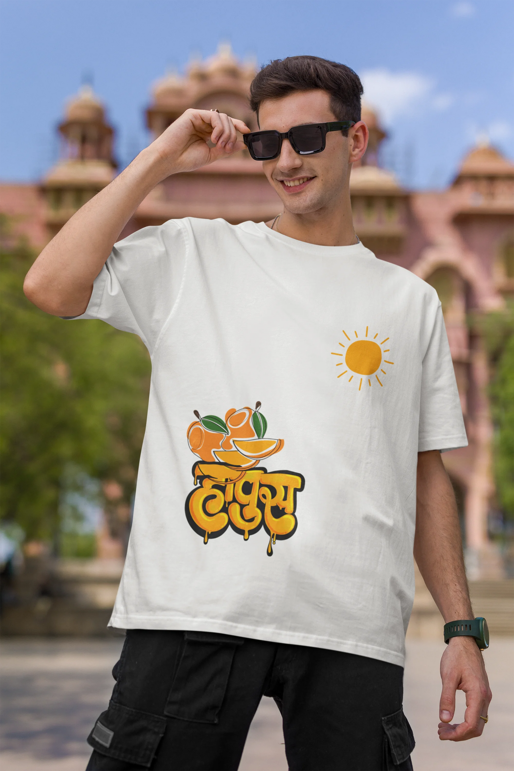 First front view of male model wearing an off-white oversized t-shirt featuring a design inspired by the Marathi word "Hapus," meaning Alphonso mango. Ideal for fans of Marathi culture, foodies, and anyone who loves the king of fruits.
