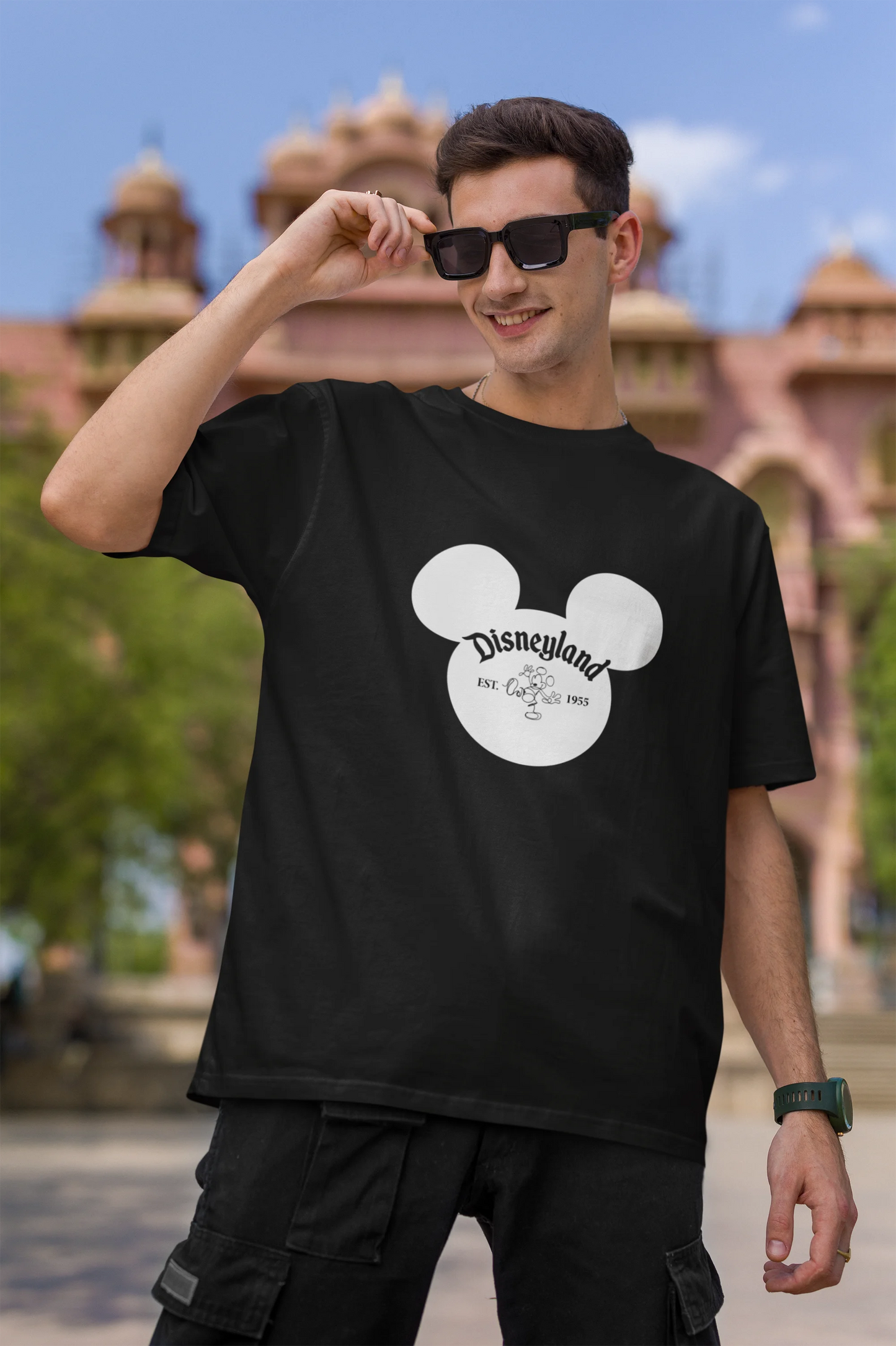 First image of male model wearing a black oversized Disney collection t-shirt featuring a classic Disneyland design.
