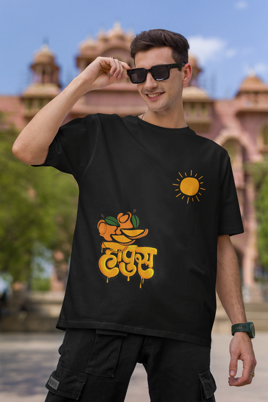 First front view of male model wearing an black oversized t-shirt featuring a design inspired by the Marathi word "Hapus," meaning Alphonso mango. Ideal for fans of Marathi culture, foodies, and anyone who loves the king of fruits.