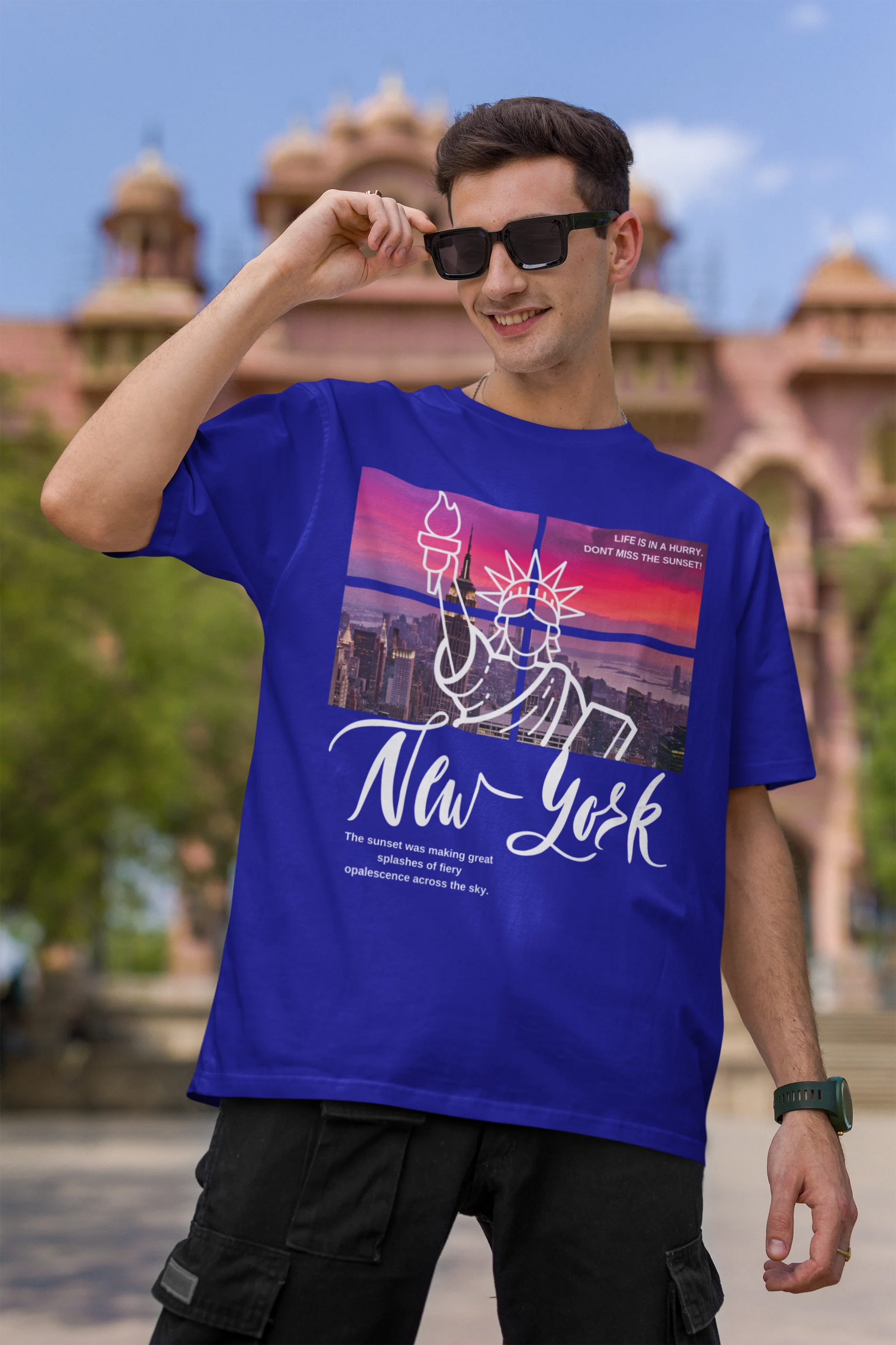First front view of a male model wearing a royal blue oversized t-shirt with a New York City skyline design, offering a relaxed urban aesthetic.