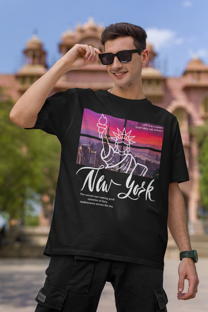 First front view of a male model wearing a black oversized t-shirt with a New York City skyline design, offering a relaxed urban aesthetic.
