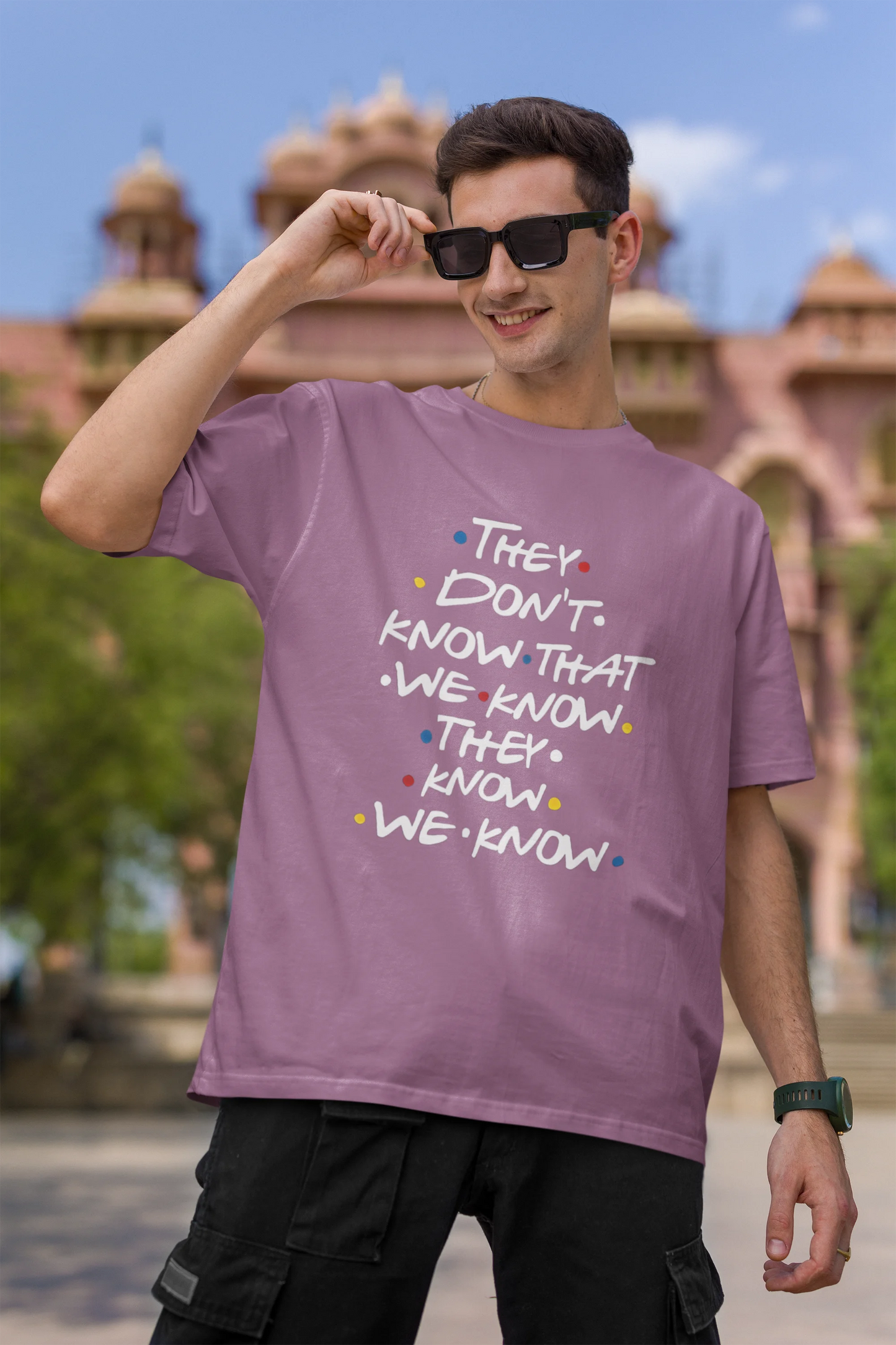First image of male model wearing dirty purple oversized t-shirt with F.R.I.E.N.D.S series inspired designs, embodying Phoebe's unique humor with the quote 'They Know We Know'