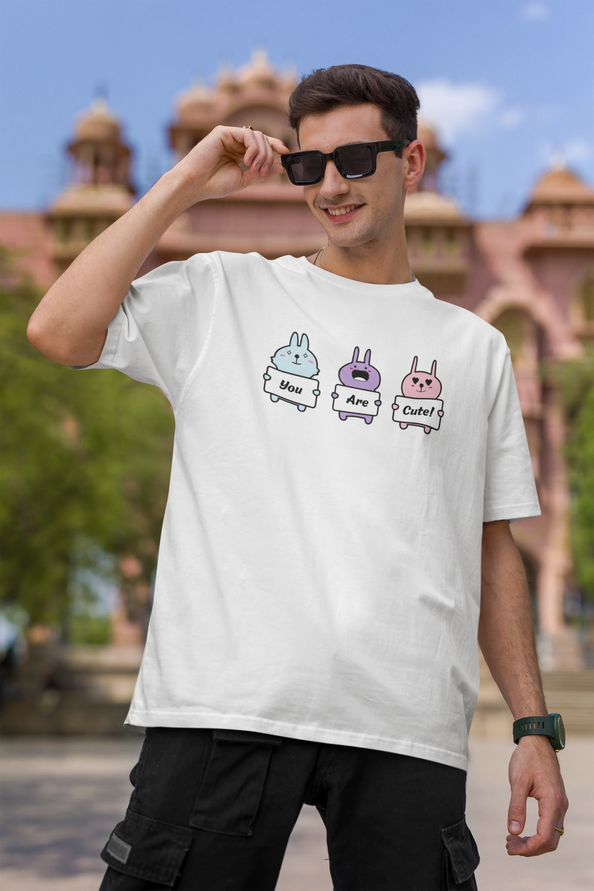 First image of male model wearing Disney-themed off-white oversized tee with a cute cartoon design