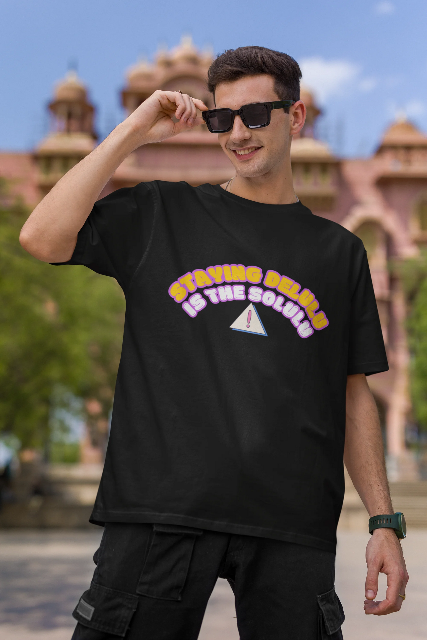 First front view of male model wearing a black oversized t-shirt with the hilarious message "Stay Delulu" in a bold design. Ideal for those who love trendy slang and lighthearted humor.