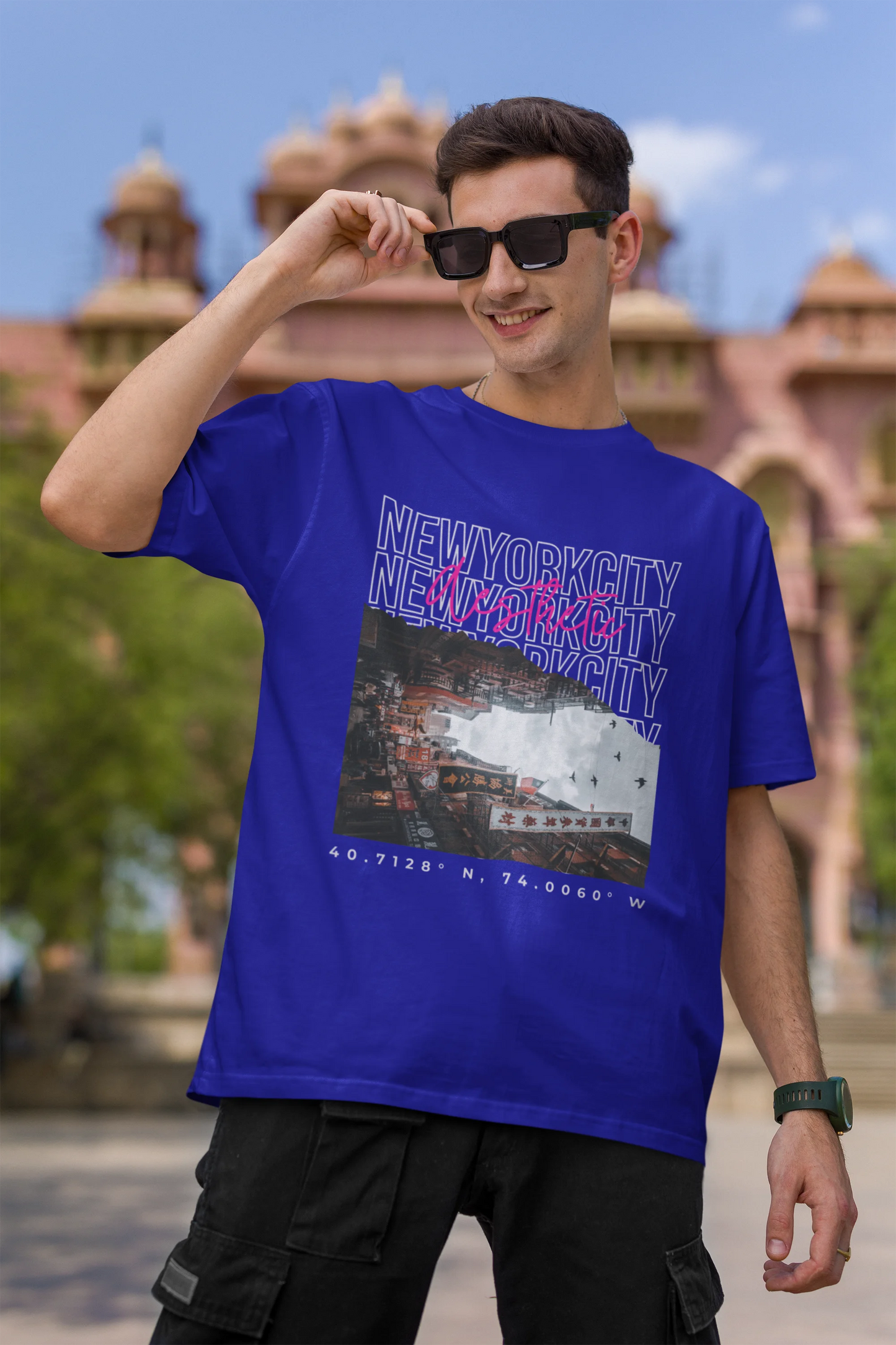First front view of a male model wearing a royal blue oversized t-shirt with a New York City skyline design, offering a relaxed urban aesthetic.